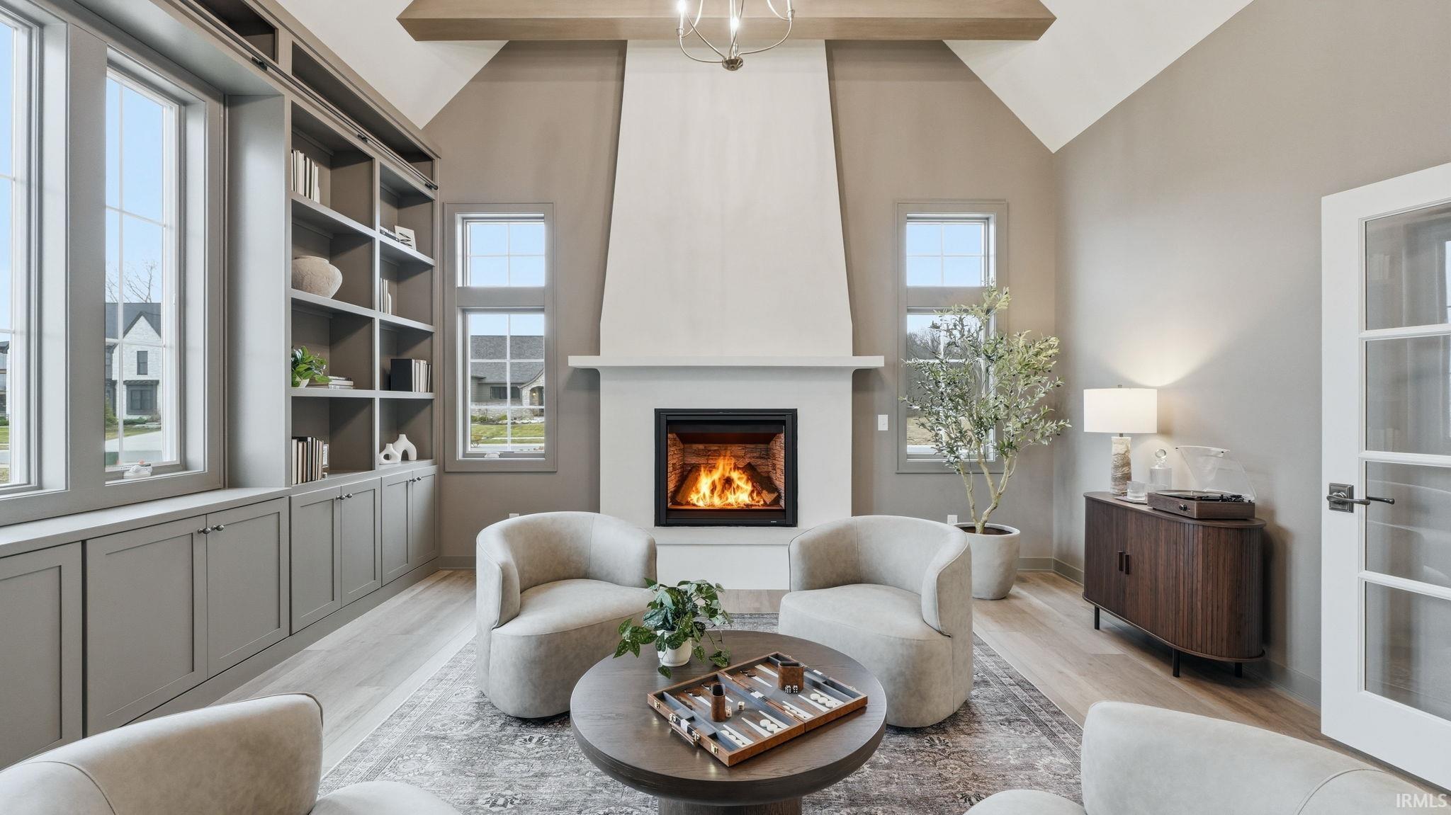 Sitting room with vaulted ceiling, wood finished floors, and a fireplace