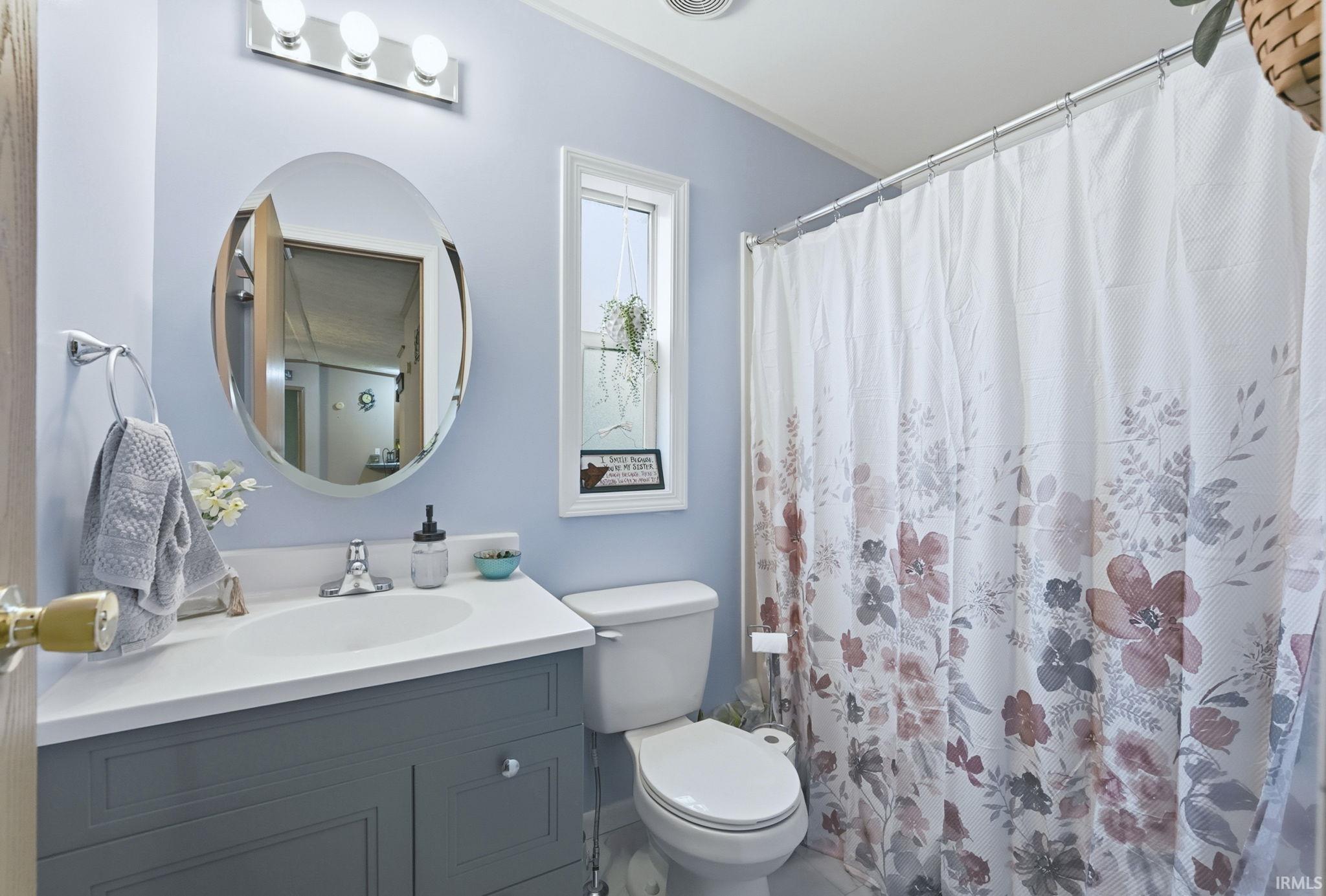 Bathroom featuring curtained shower and vanity