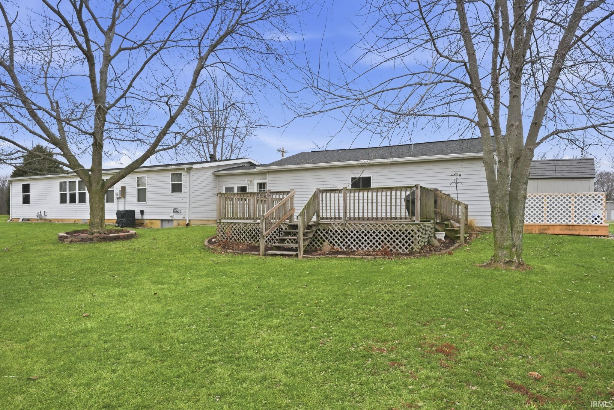 Back of house featuring a lawn and a deck