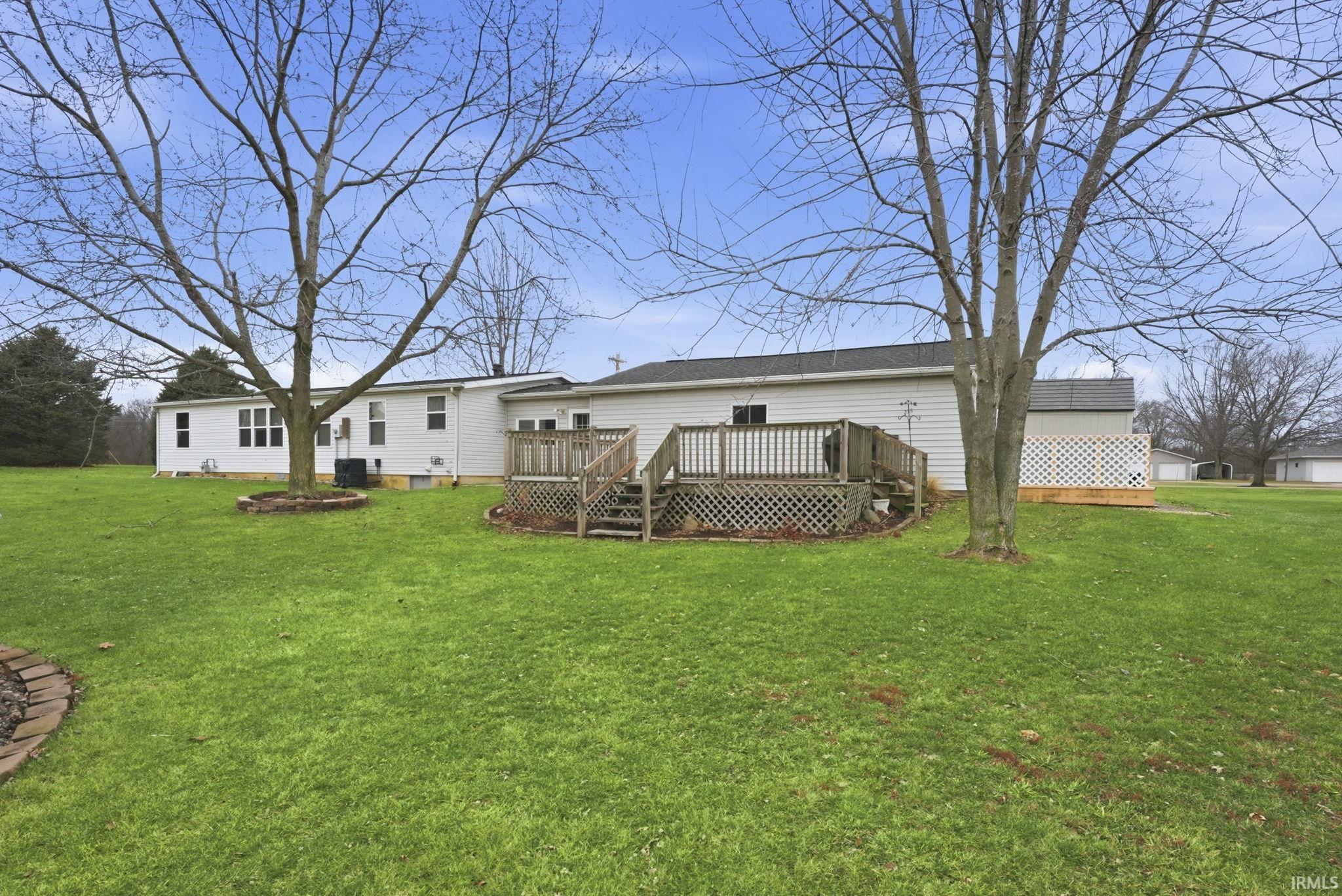 Back of property featuring a yard and a wooden deck