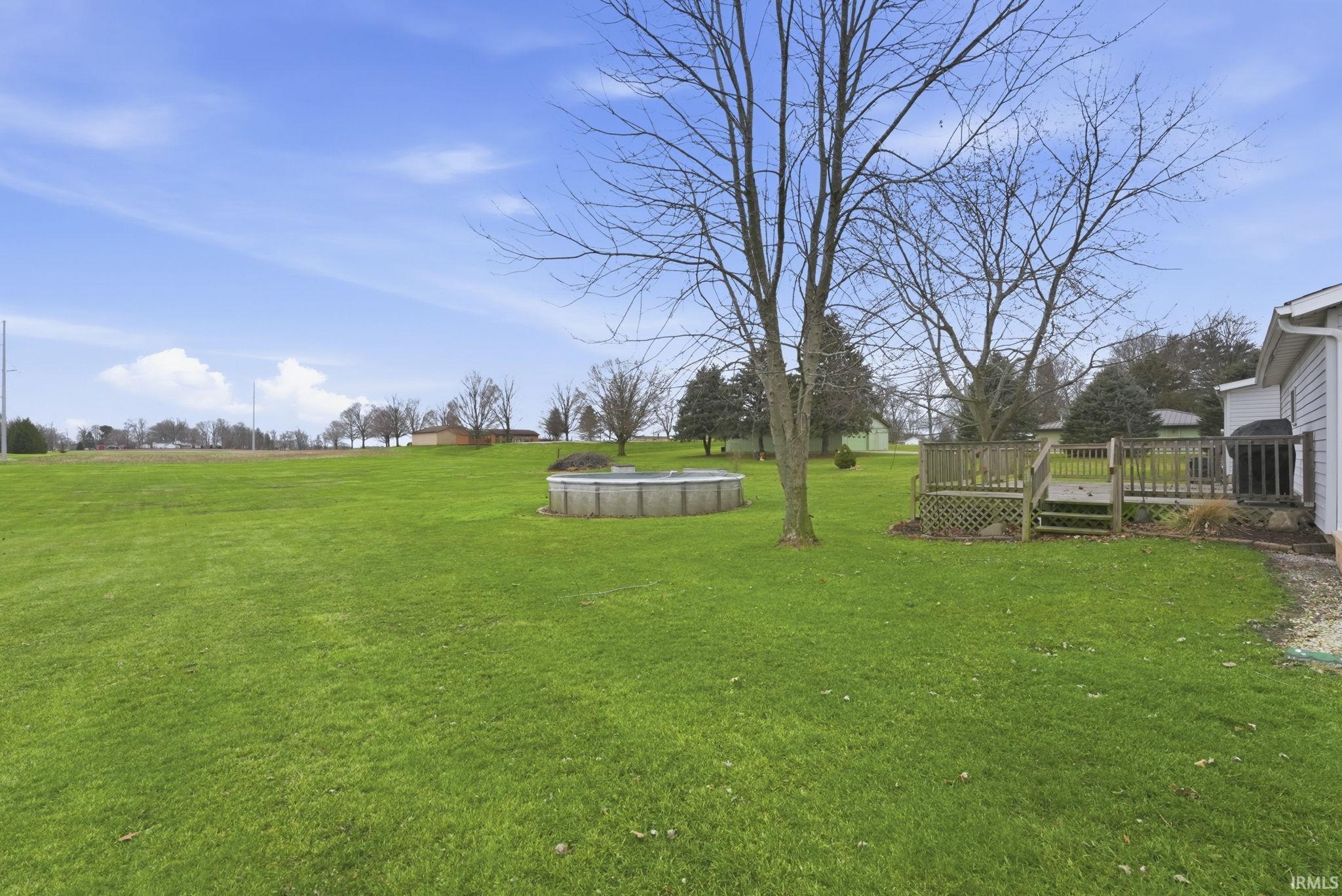 View of green lawn with a wooden deck