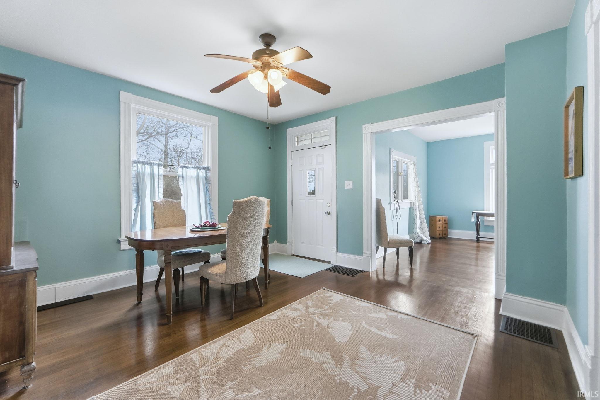 Dining space with a ceiling fan and dark wood-style floors