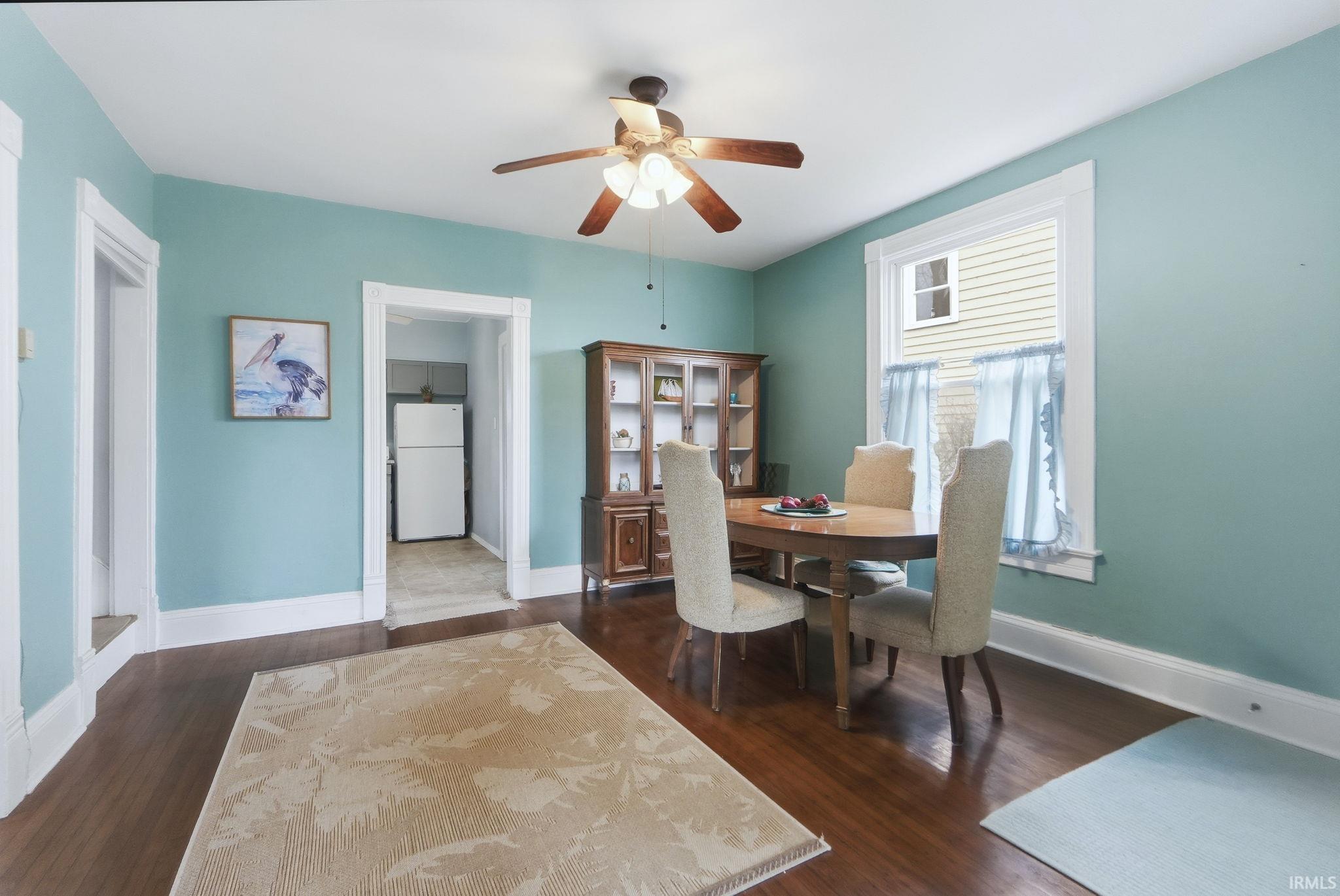 Dining space with a ceiling fan and dark wood finished floors