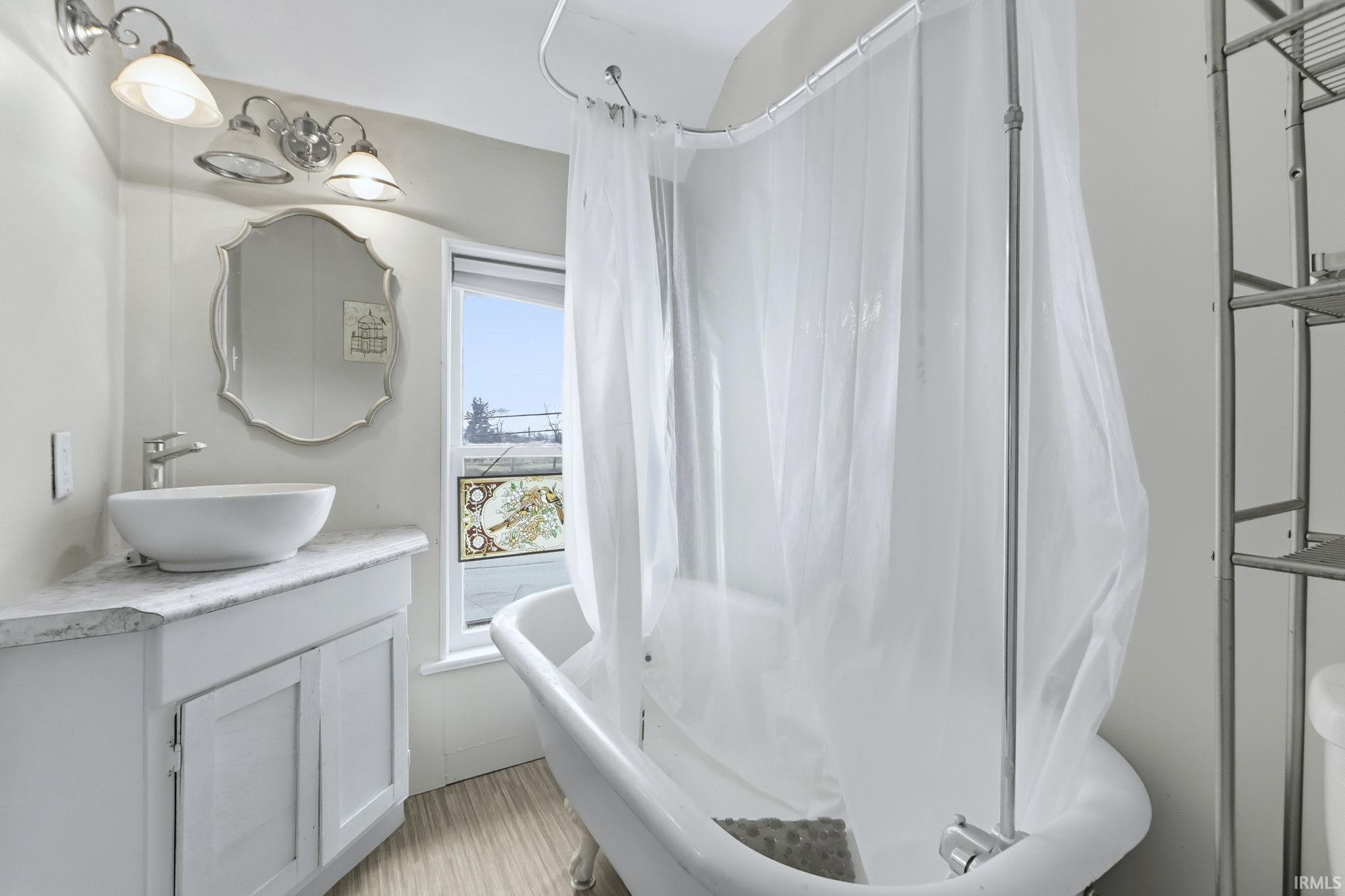 Bathroom with vanity and shower / bath combination with curtain