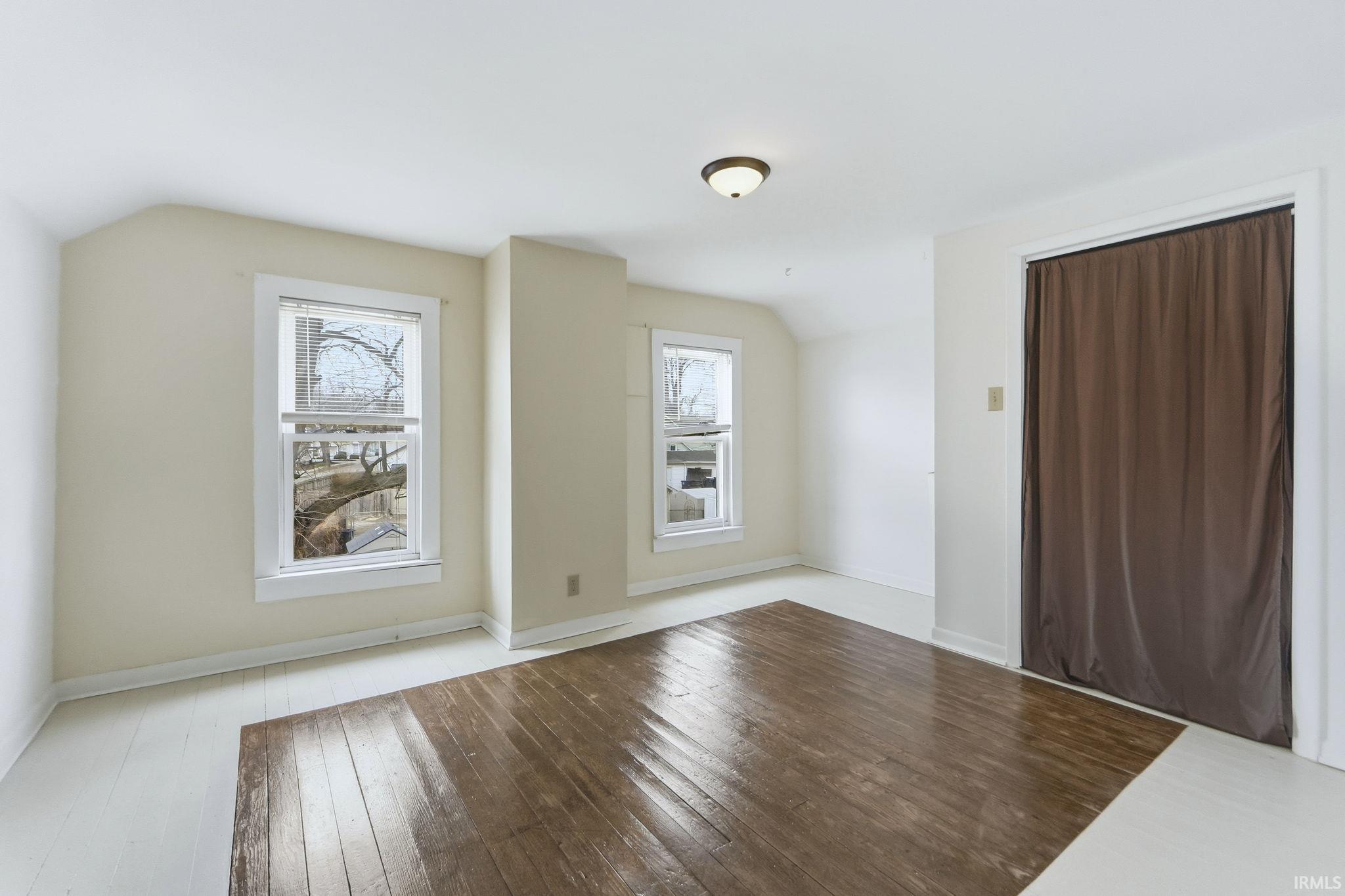 Interior space with wood-type flooring and lofted ceiling