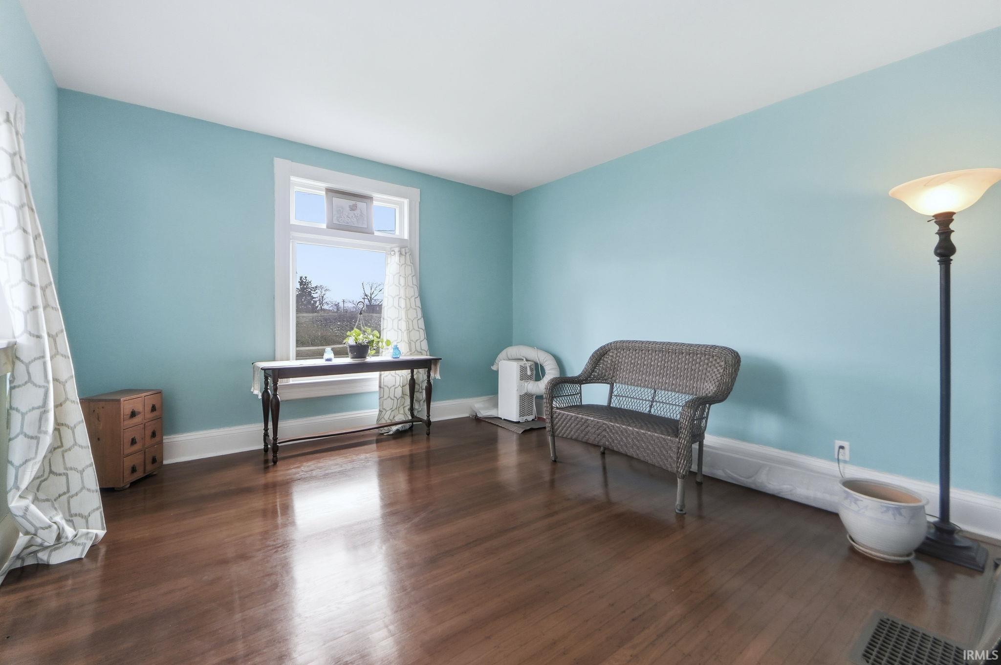Living area with dark wood-style flooring and baseboards