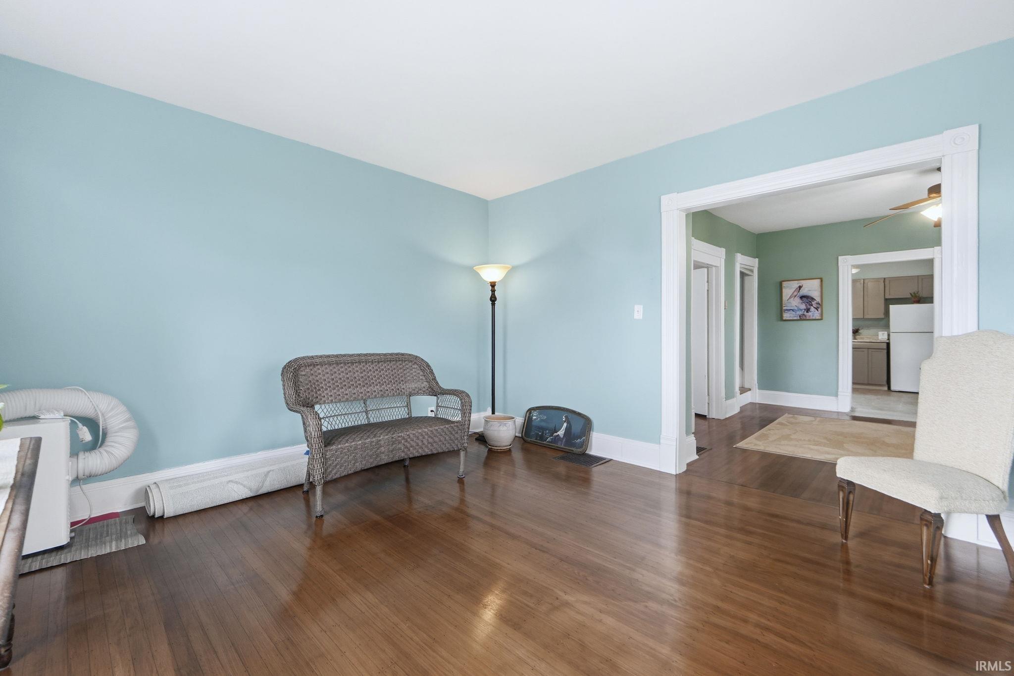 Sitting room featuring dark wood-type flooring and ceiling fan