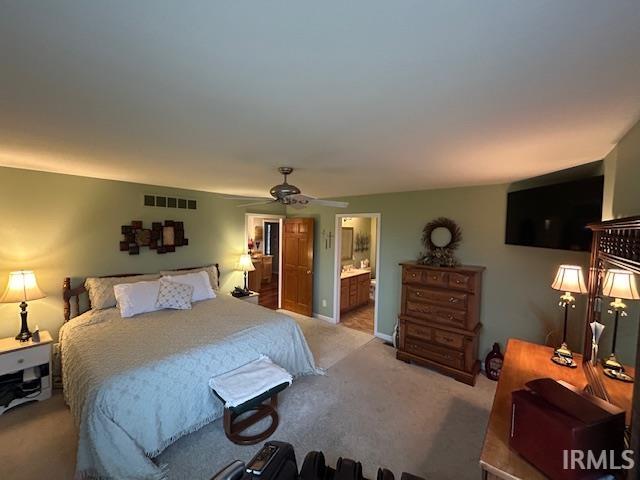 Carpeted bedroom with a ceiling fan and ensuite bathroom