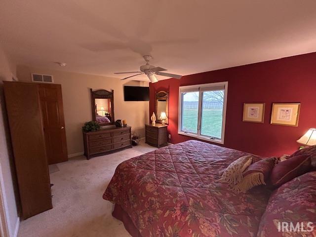 Carpeted bedroom with a ceiling fan and baseboards