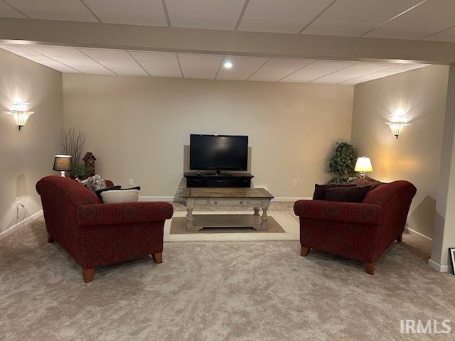 Carpeted living room with recessed lighting and beamed ceiling