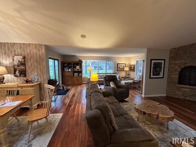 Living area featuring a stone fireplace and dark wood finished floors