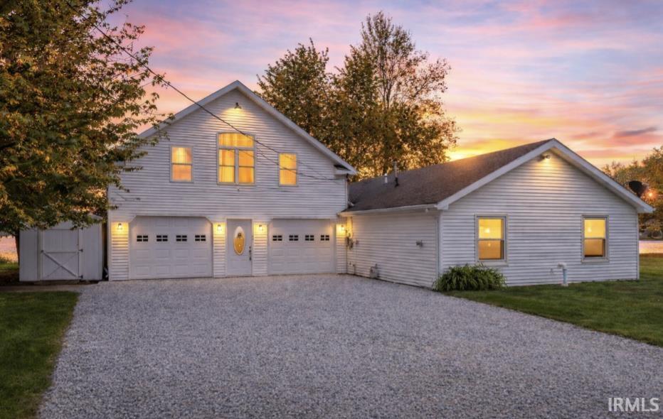 View of front of home featuring driveway, a garage, and a front lawn