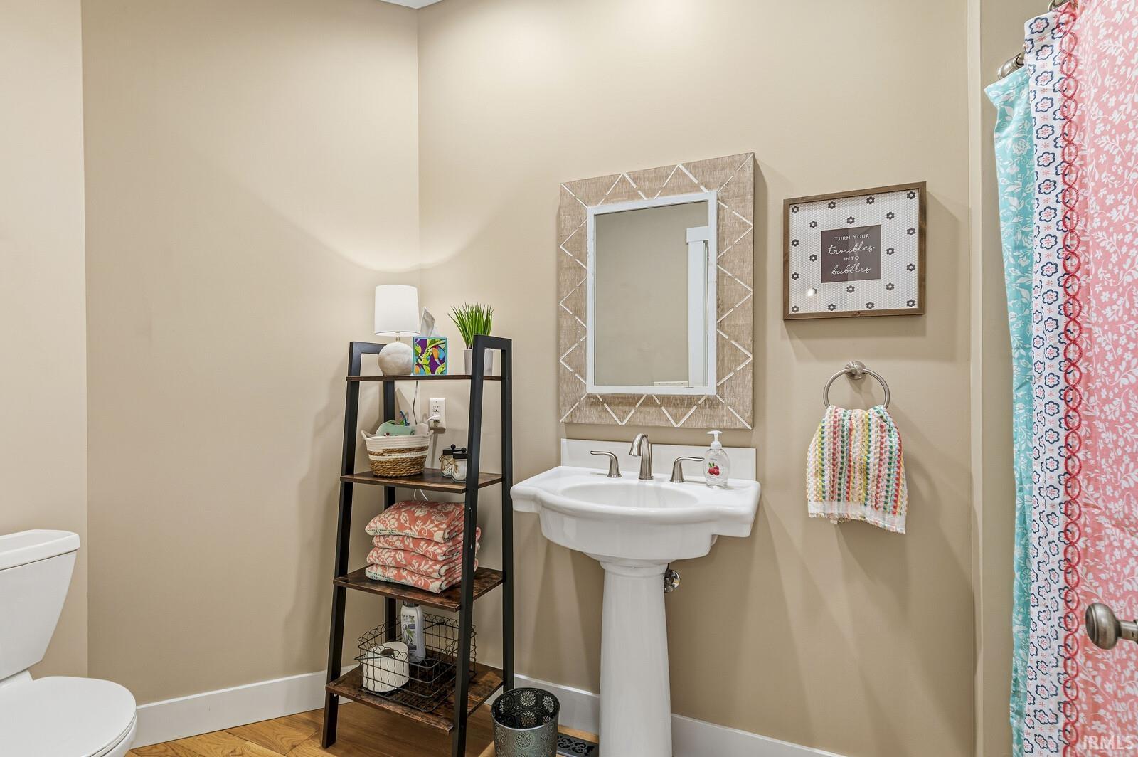 Bathroom featuring wood finished floors and curtained shower