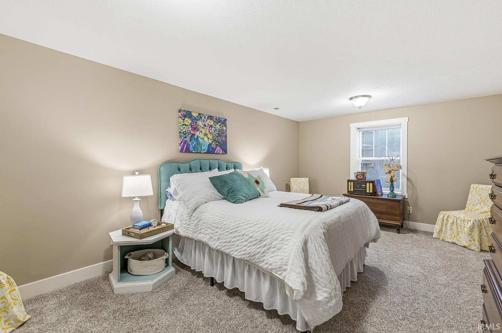 Bedroom featuring light carpet