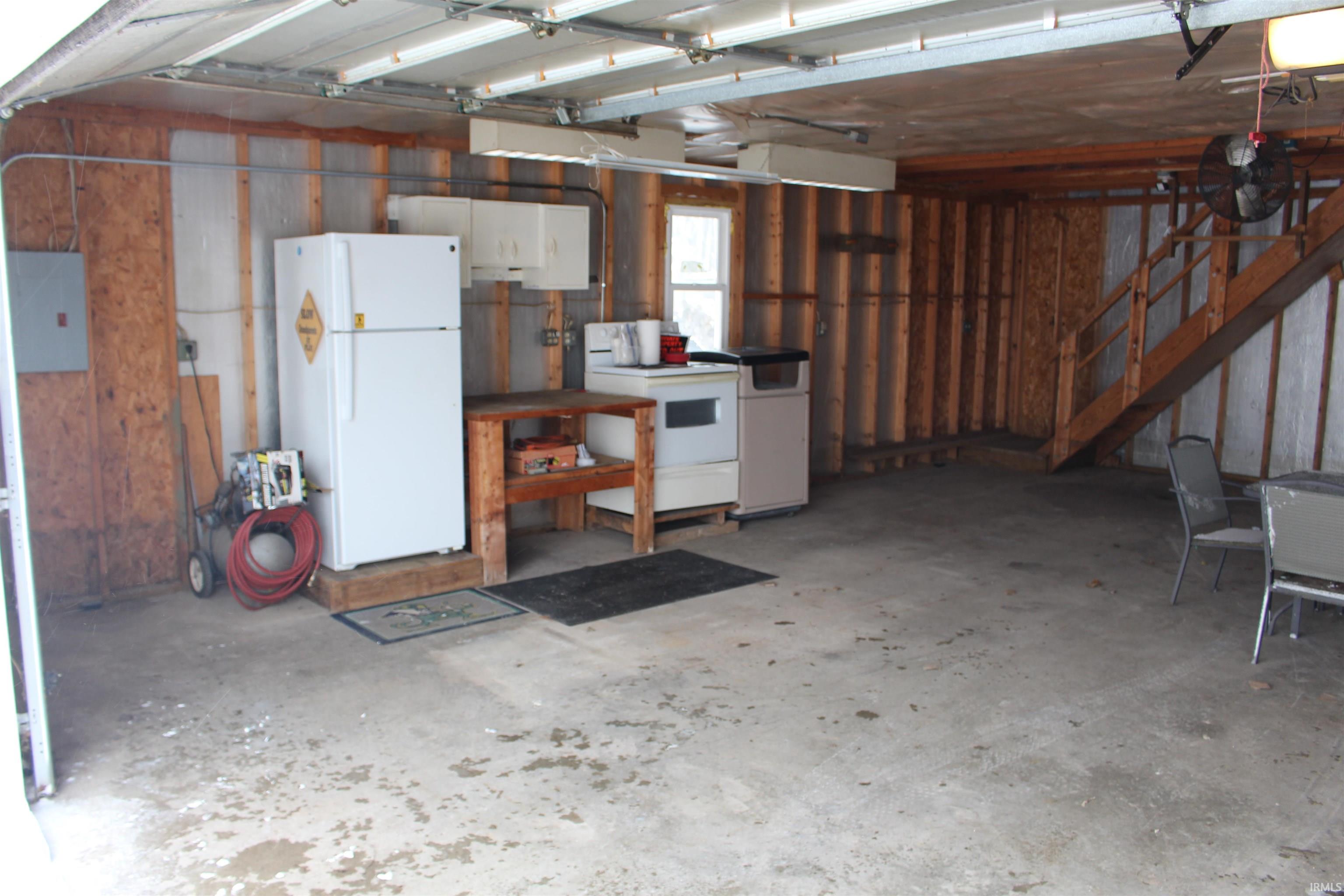 Garage with freestanding refrigerator and electric panel