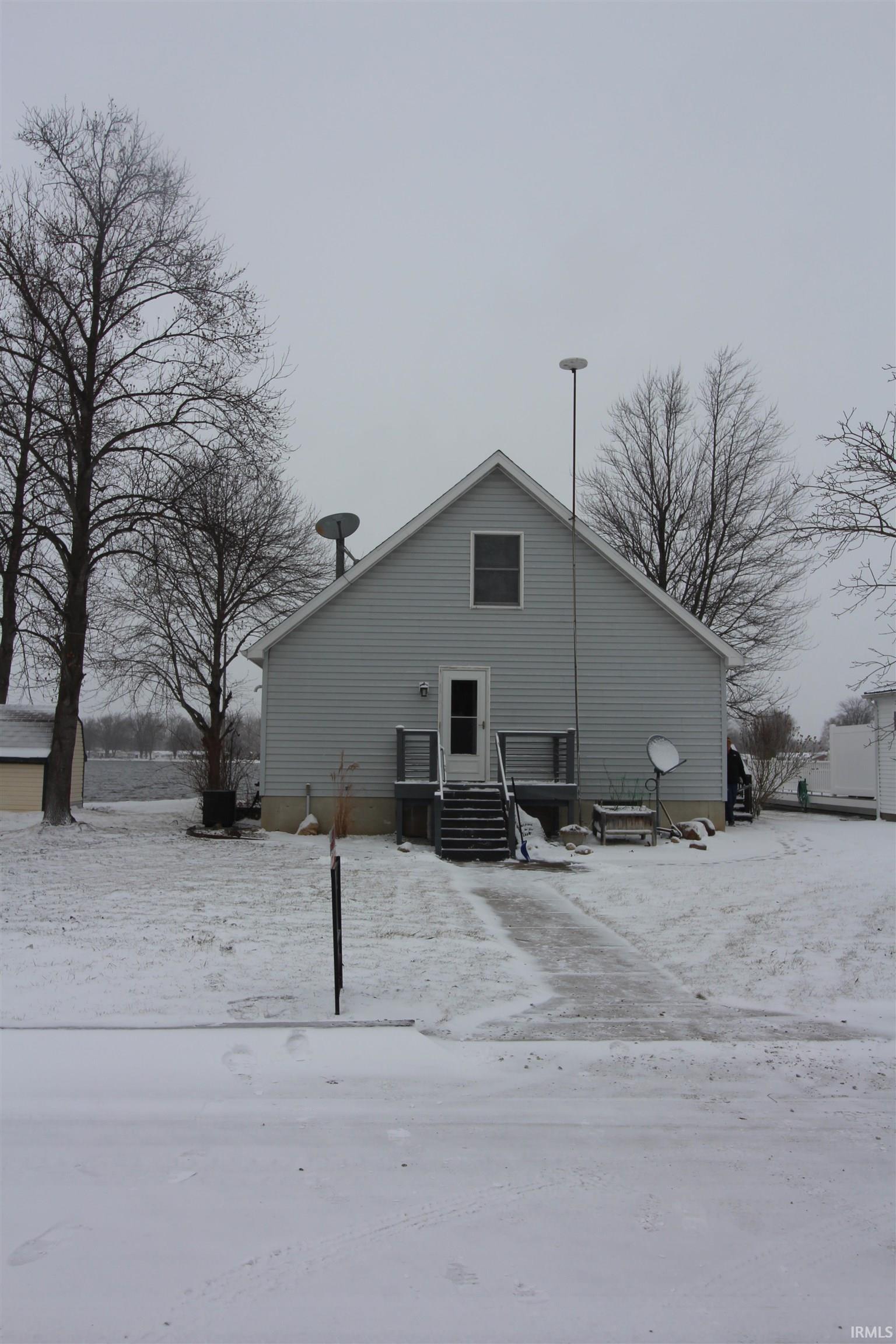 Snow covered back of property with entry steps