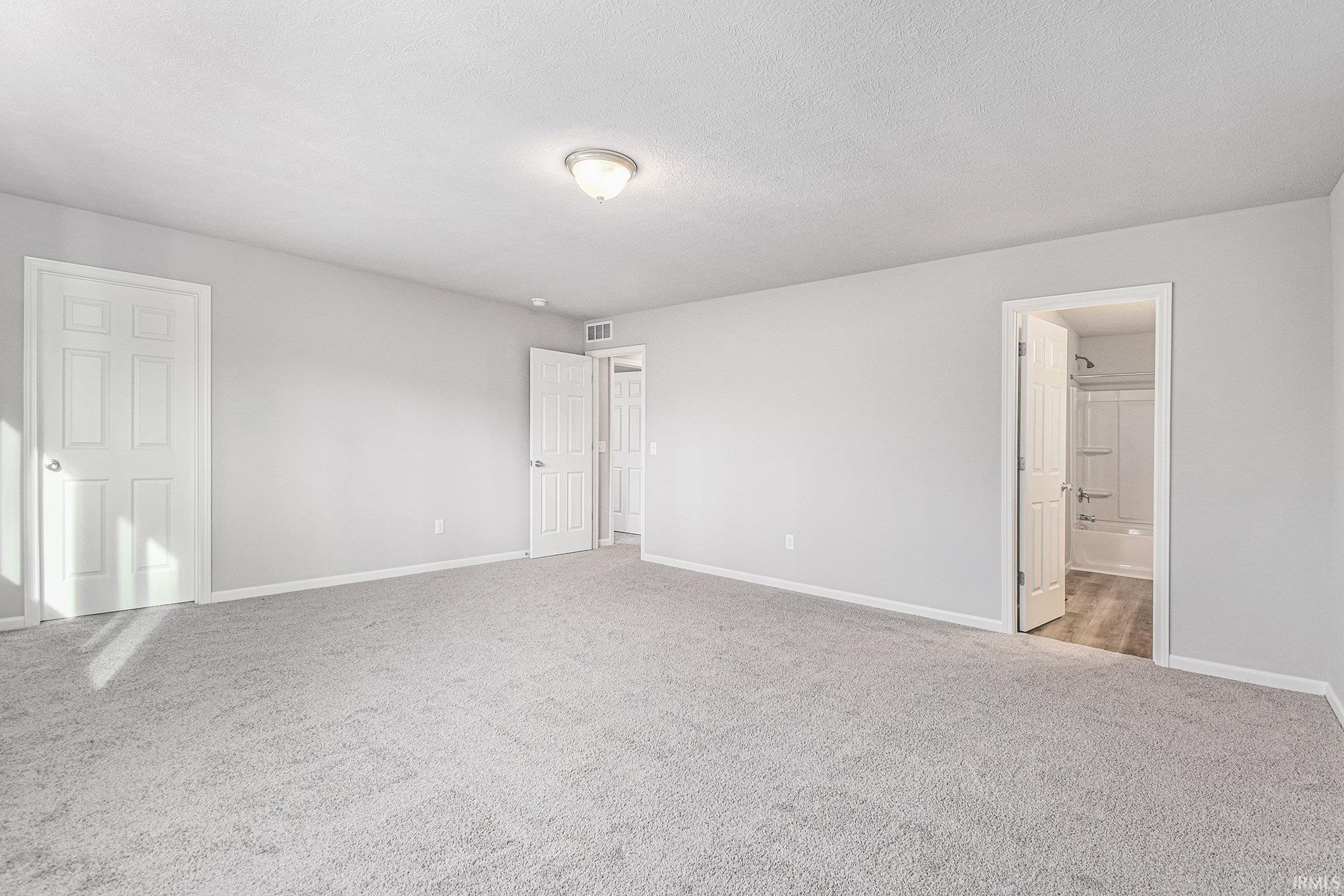 The spacious primary suite includes a private bath and oversized walk-in closet.