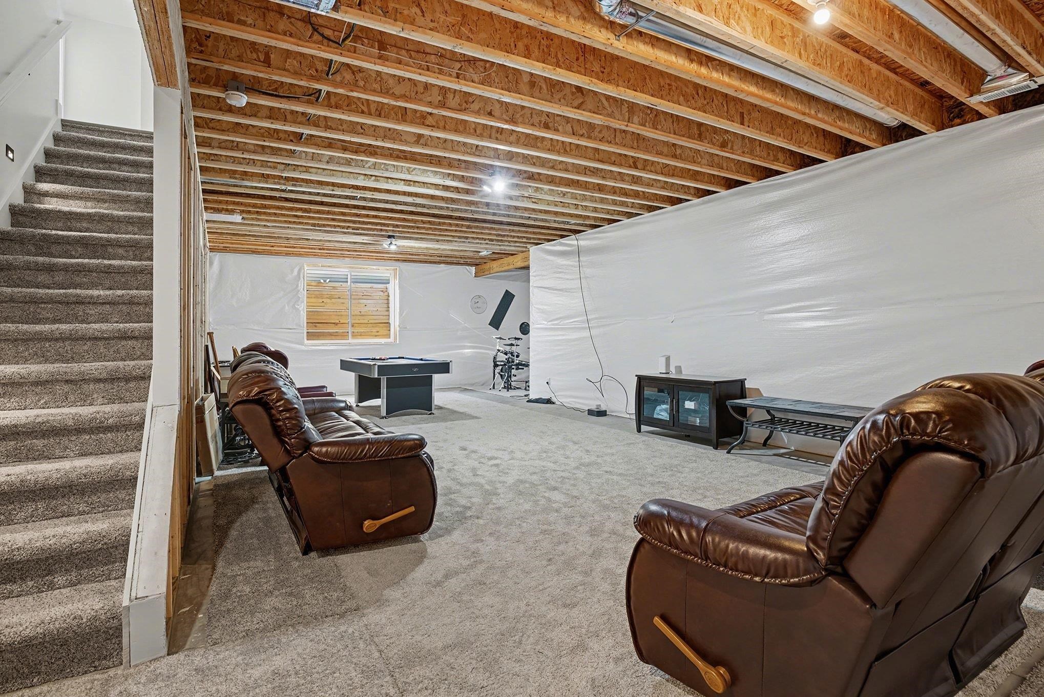 Carpeted living area featuring stairs