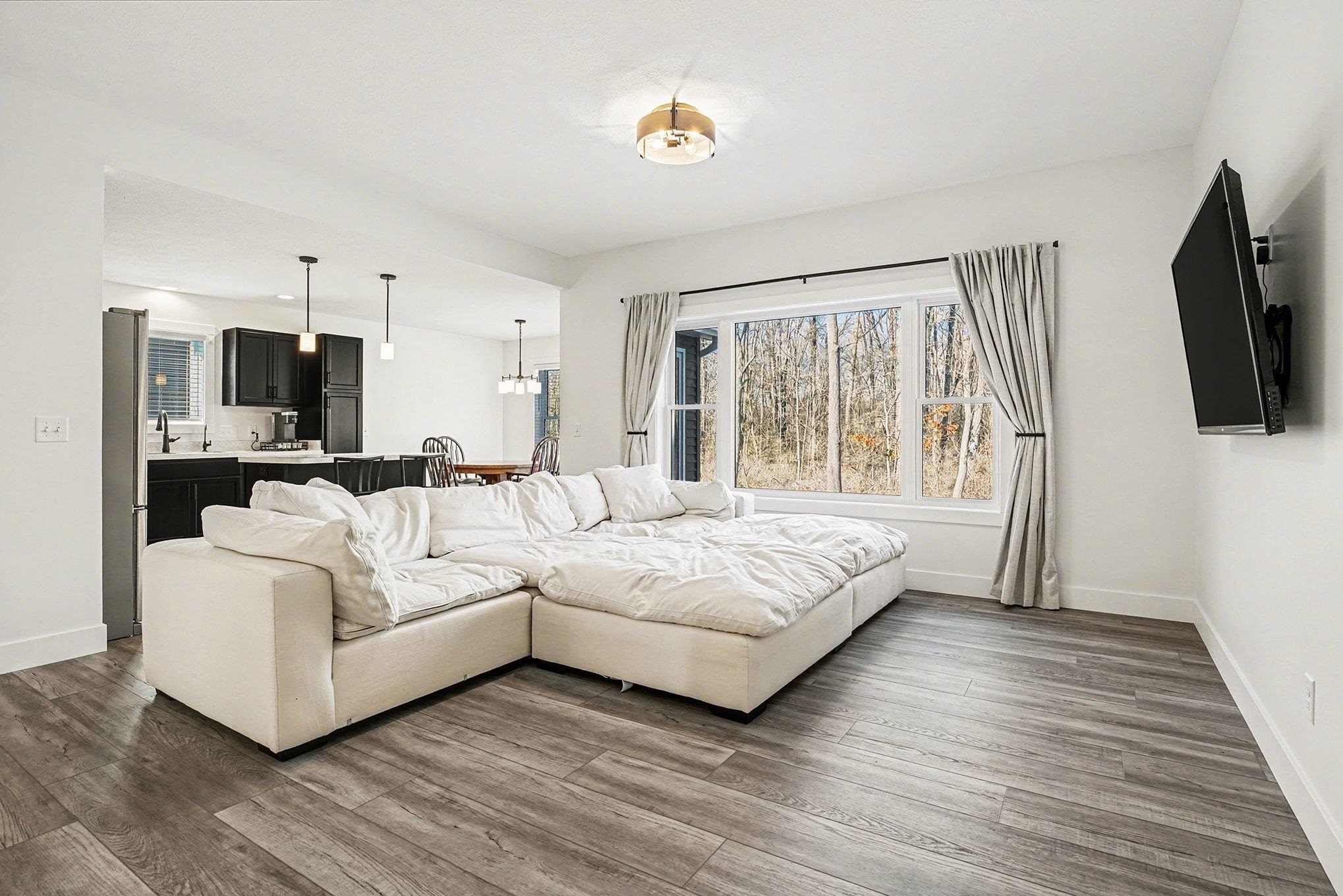 Living area featuring plenty of natural light, wood finished floors, and a chandelier