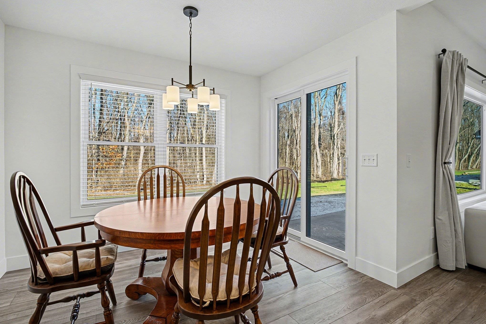 Dining room with a chandelier, wood finished floors, and plenty of natural light