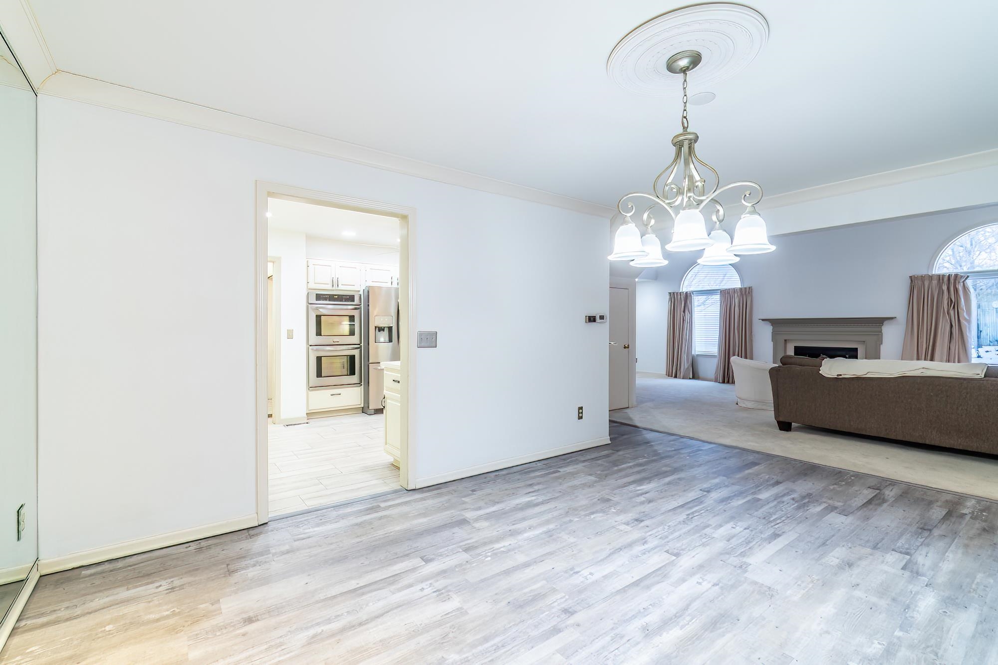 Unfurnished dining area featuring a fireplace, crown molding, light wood-style floors, and a chandelier