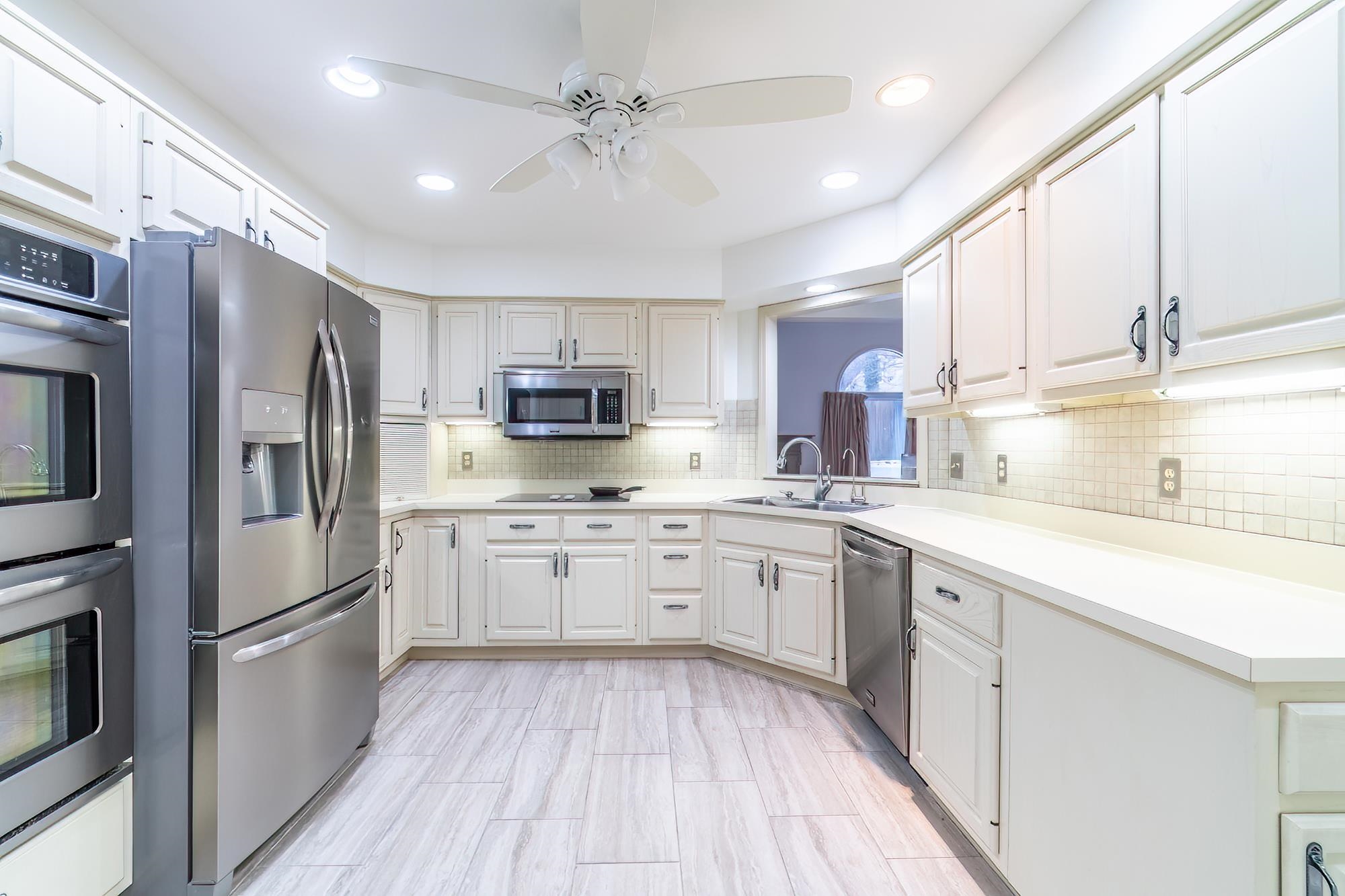 Kitchen featuring appliances with stainless steel finishes, light countertops, ceiling fan, white cabinetry, and recessed lighting
