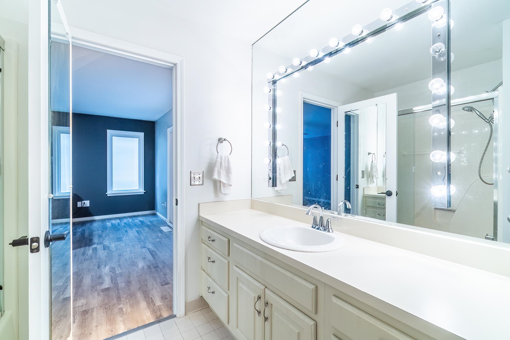 Bathroom featuring vanity, an enclosed shower, and light wood-style flooring