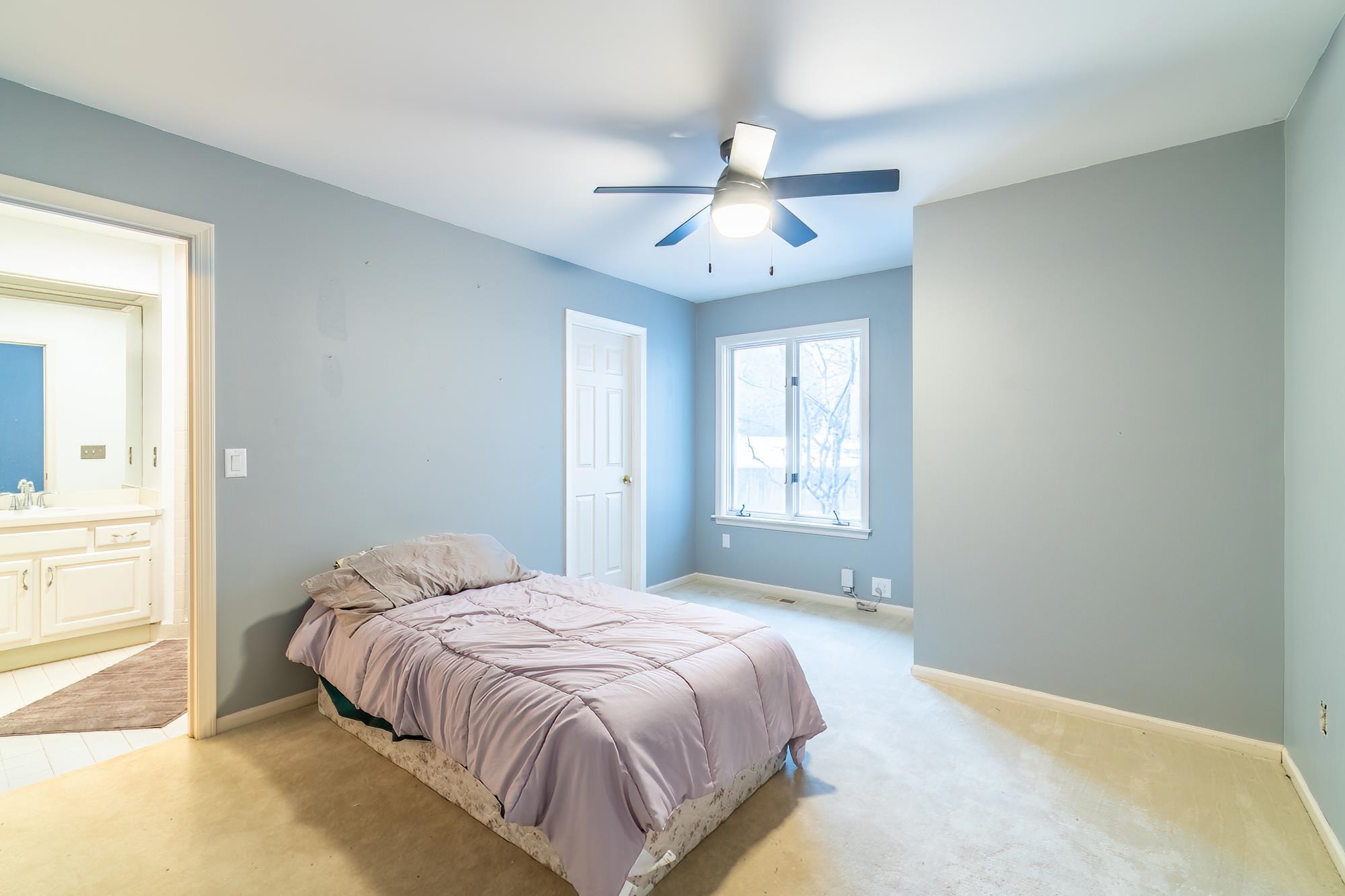 Bedroom with light carpet and a ceiling fan