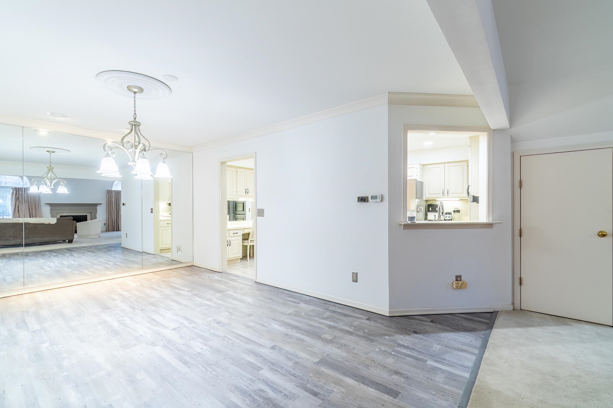 Unfurnished living room with a fireplace, ornamental molding, light wood-style flooring, and a chandelier