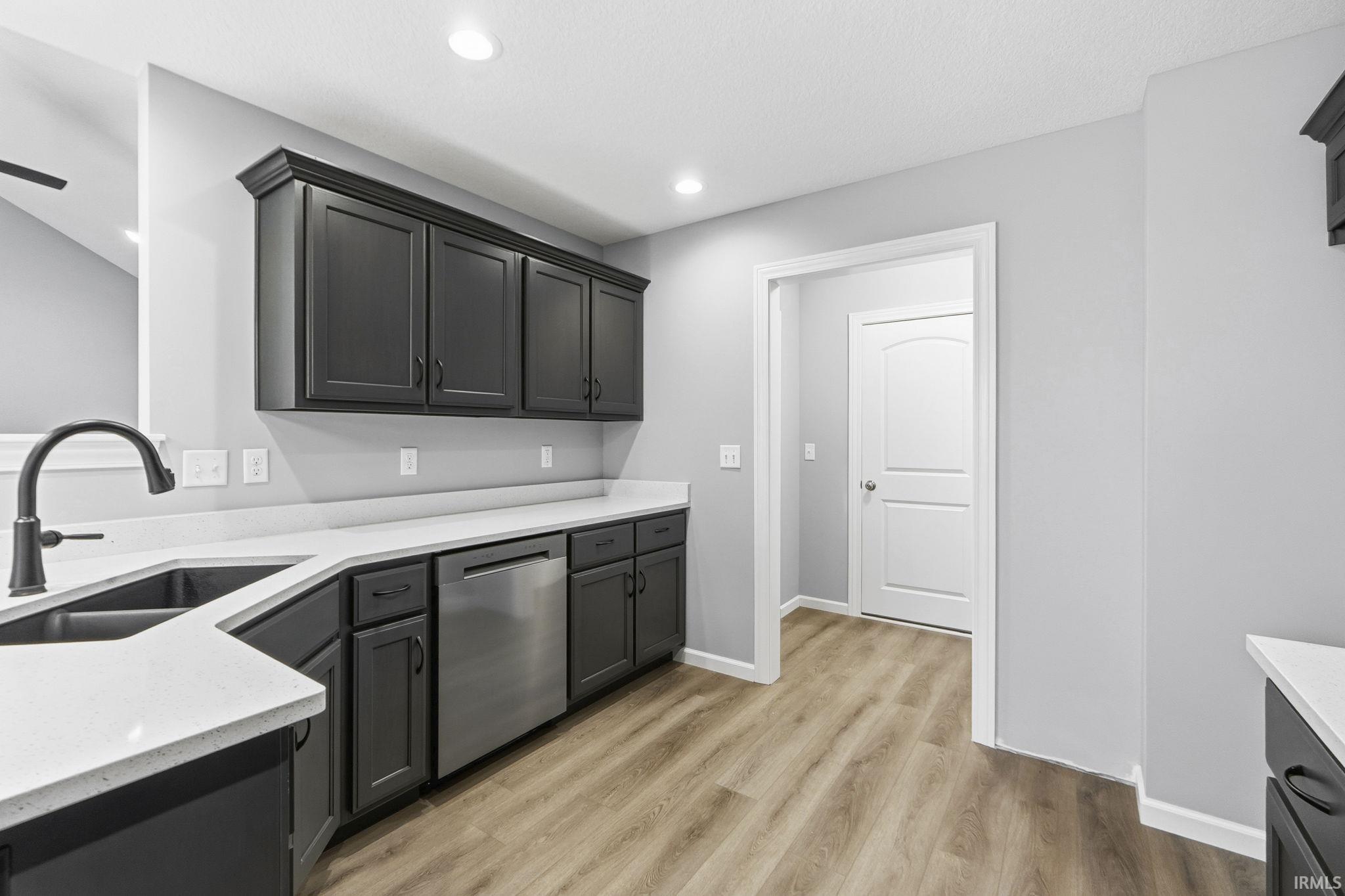 Kitchen with dishwasher, light stone counters, light wood-style floors, recessed lighting, and gray cabinets