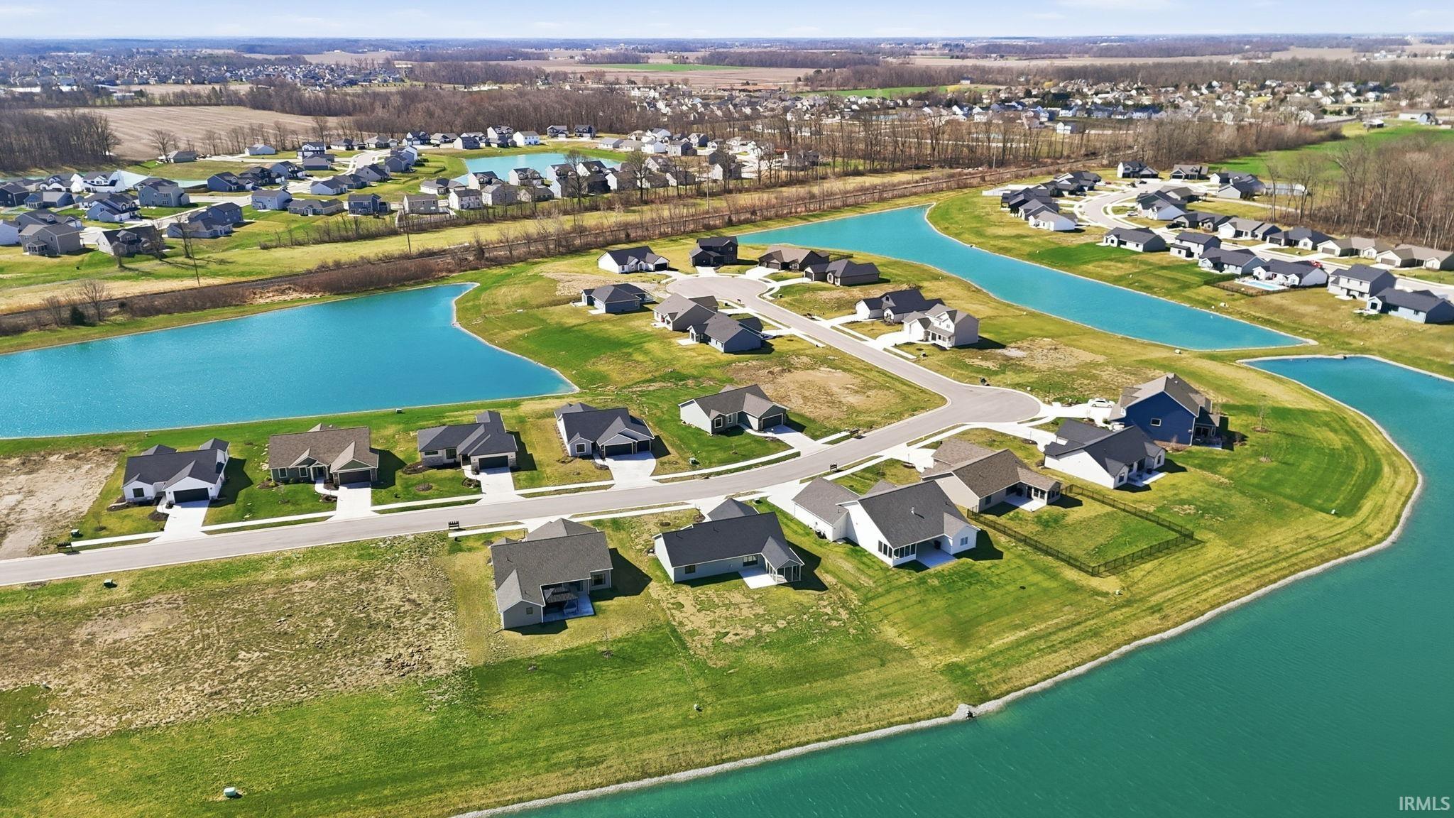 Aerial view of property and surrounding area with nearby suburban area and a large body of water