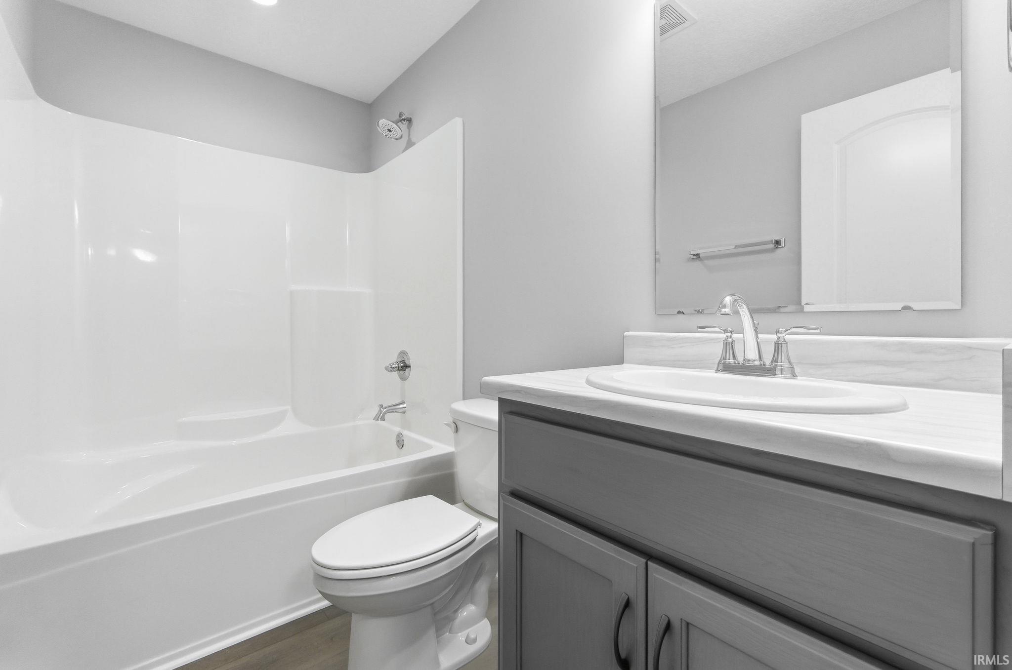 Full bathroom featuring  shower combination, vanity, and dark wood finished floors