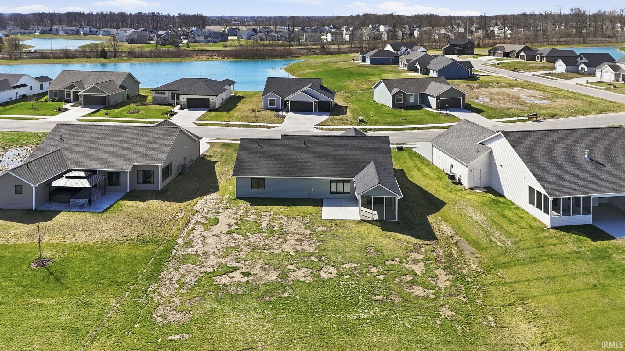 Aerial perspective of suburban area featuring a nearby body of water