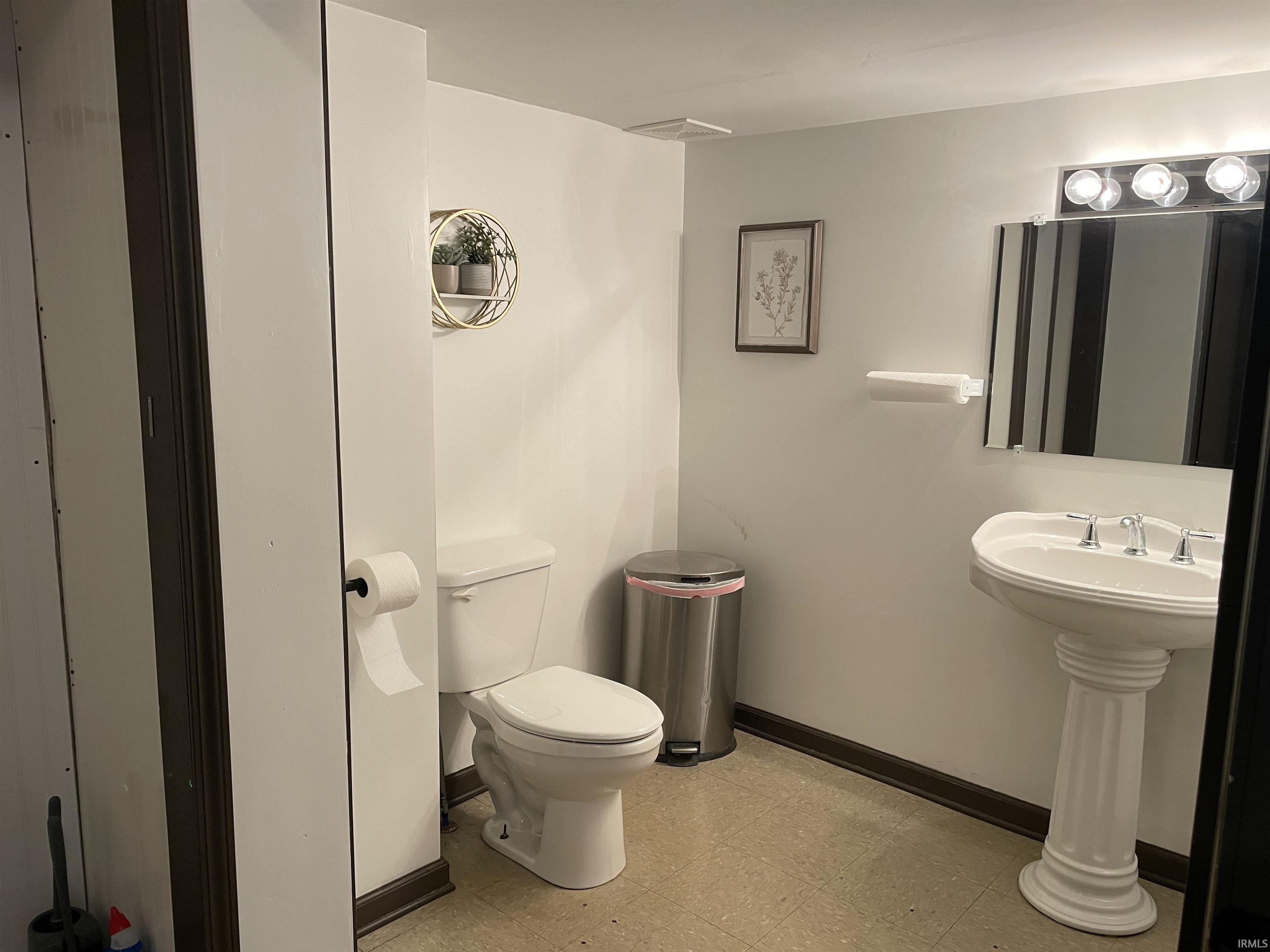 Half bathroom with light flooring and toilet