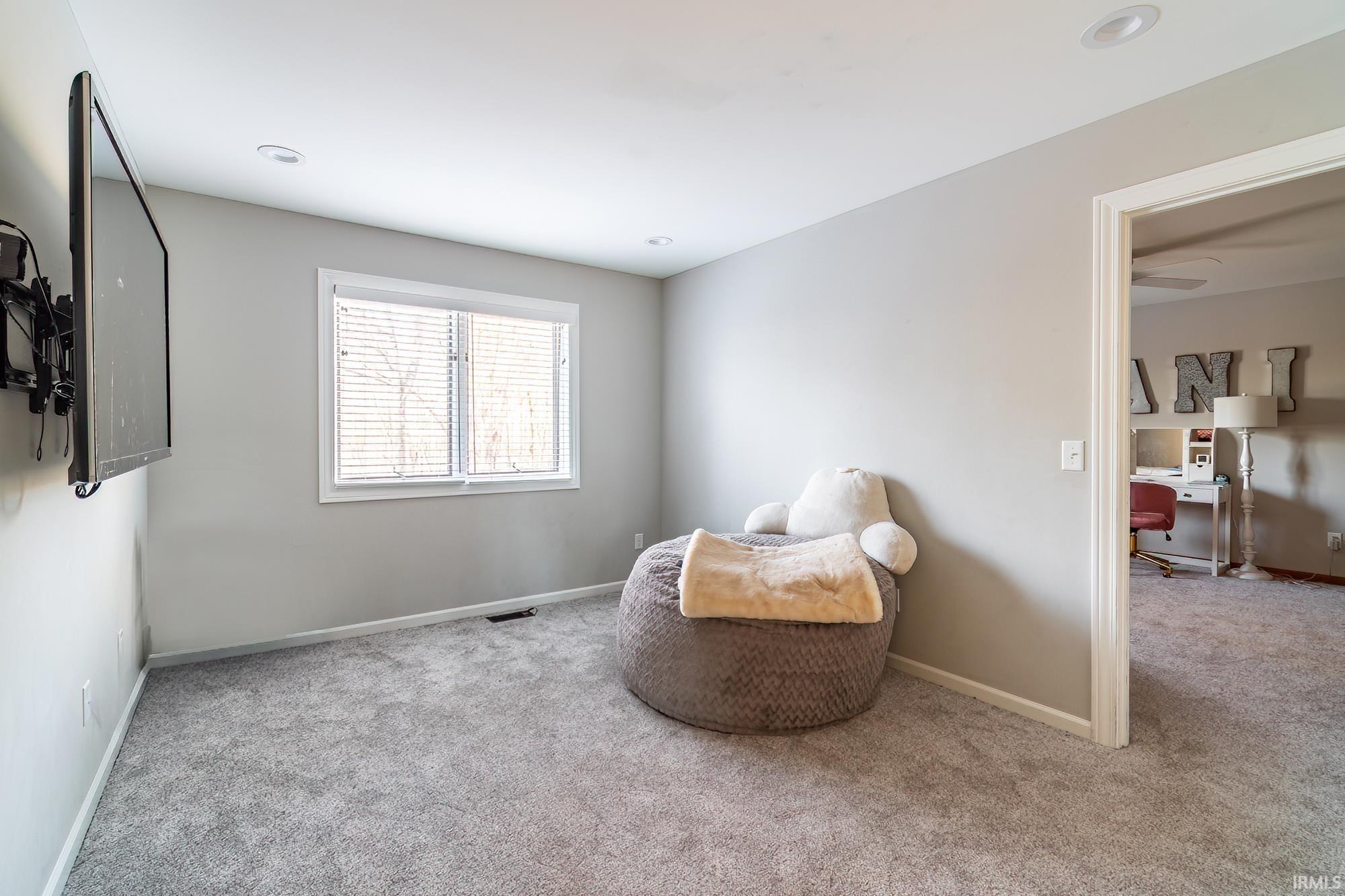 Sitting room with carpet flooring and a desk