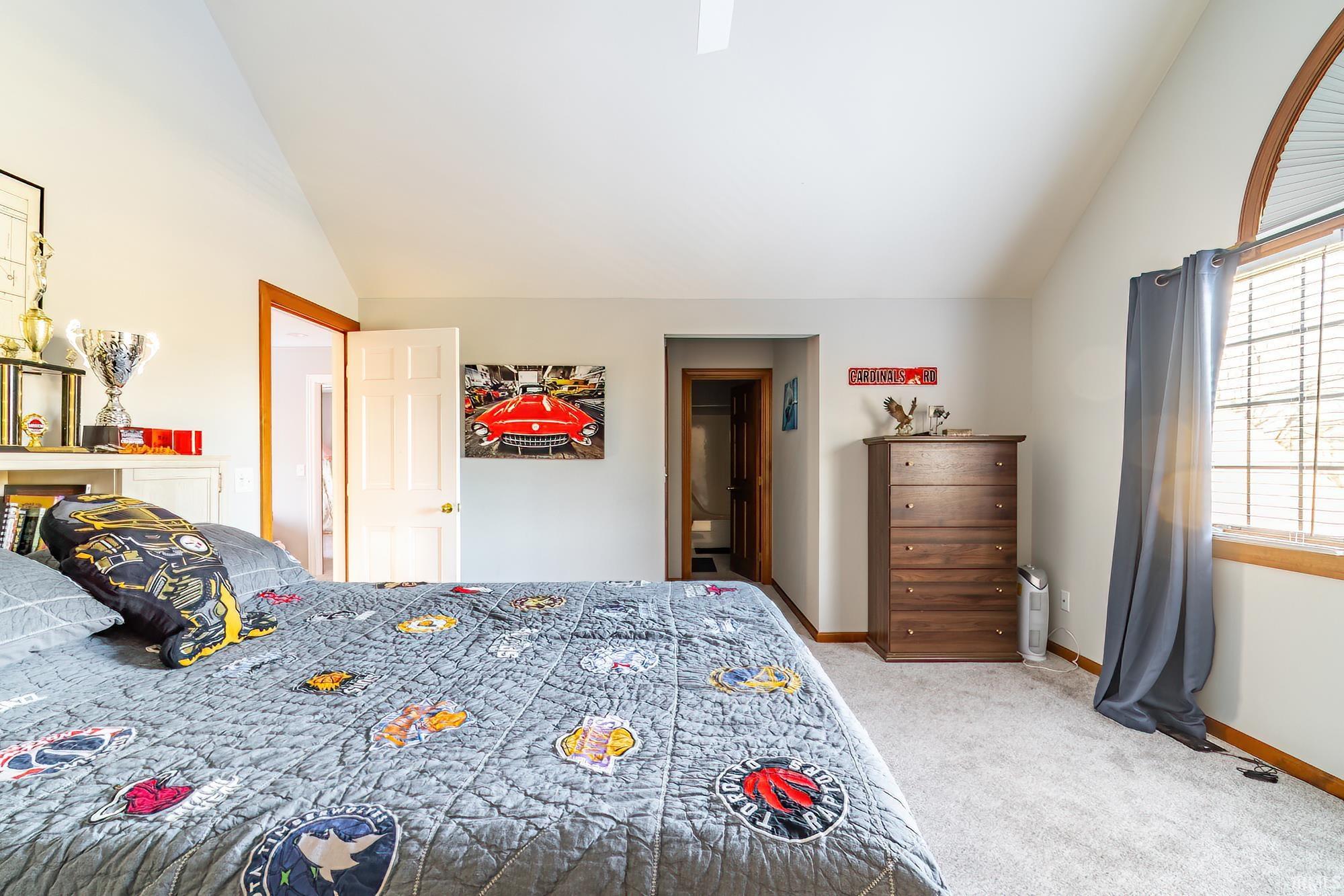 Bedroom featuring lofted ceiling, light carpet, and ceiling fan
