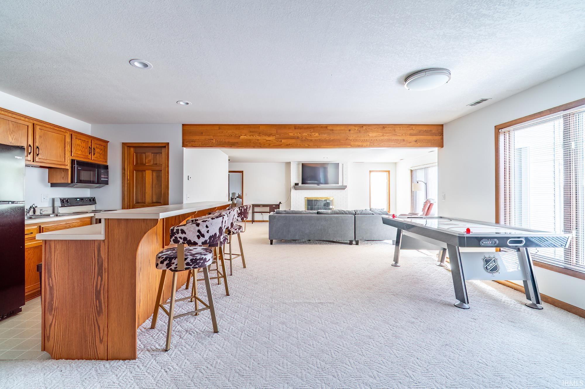 Rec room featuring a glass covered fireplace, recessed lighting, and a textured ceiling