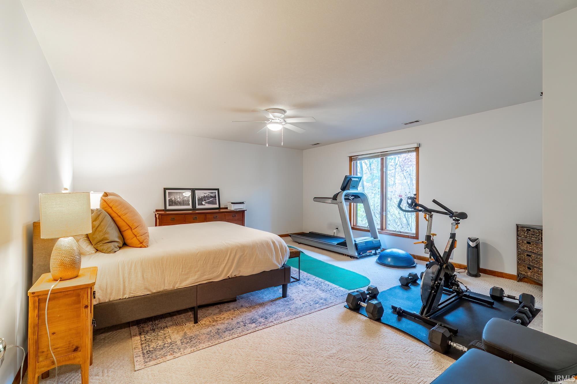 Bedroom with carpet, a ceiling fan, and access to exterior