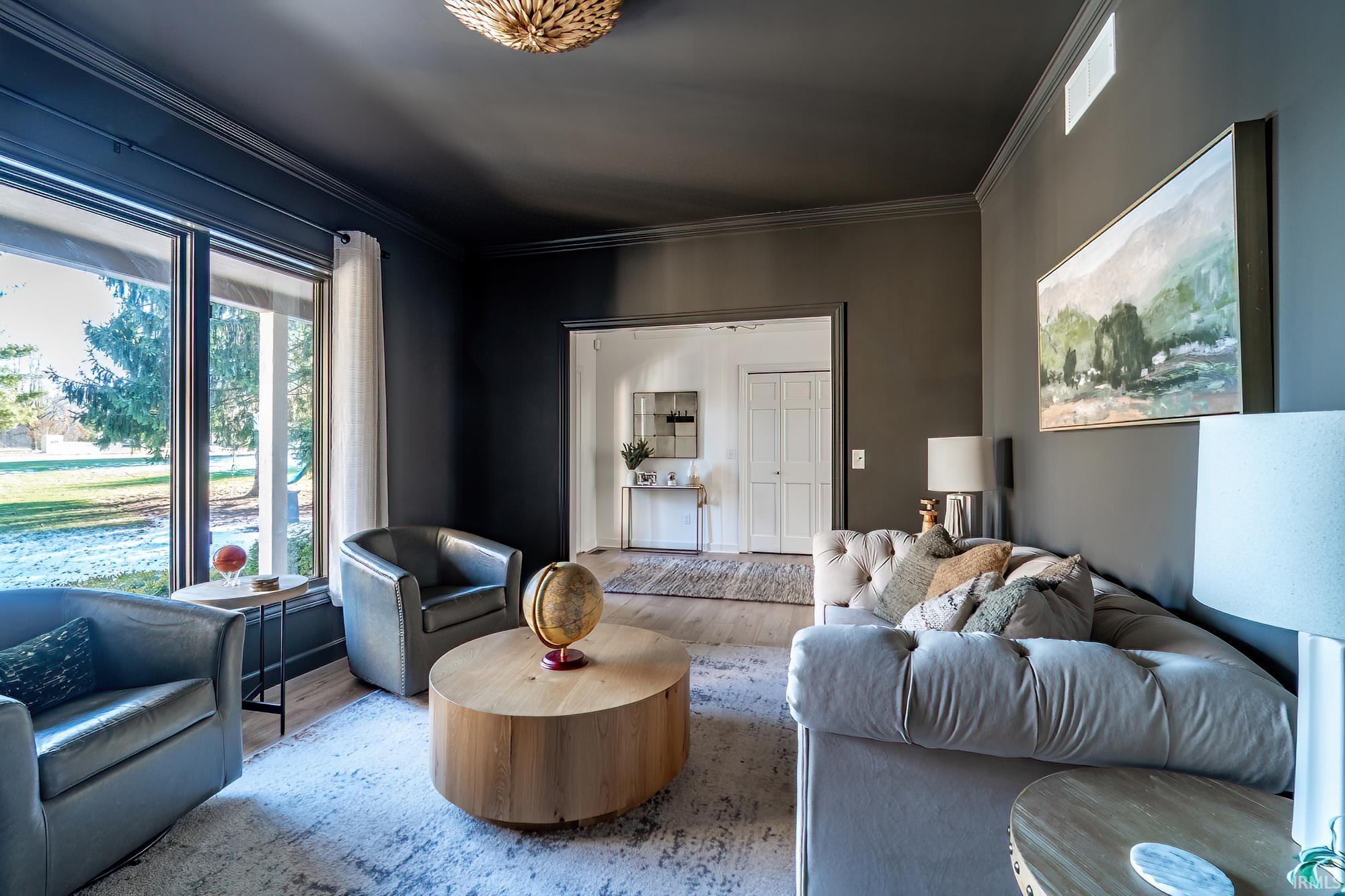 Living area featuring ornamental molding and wood finished floors