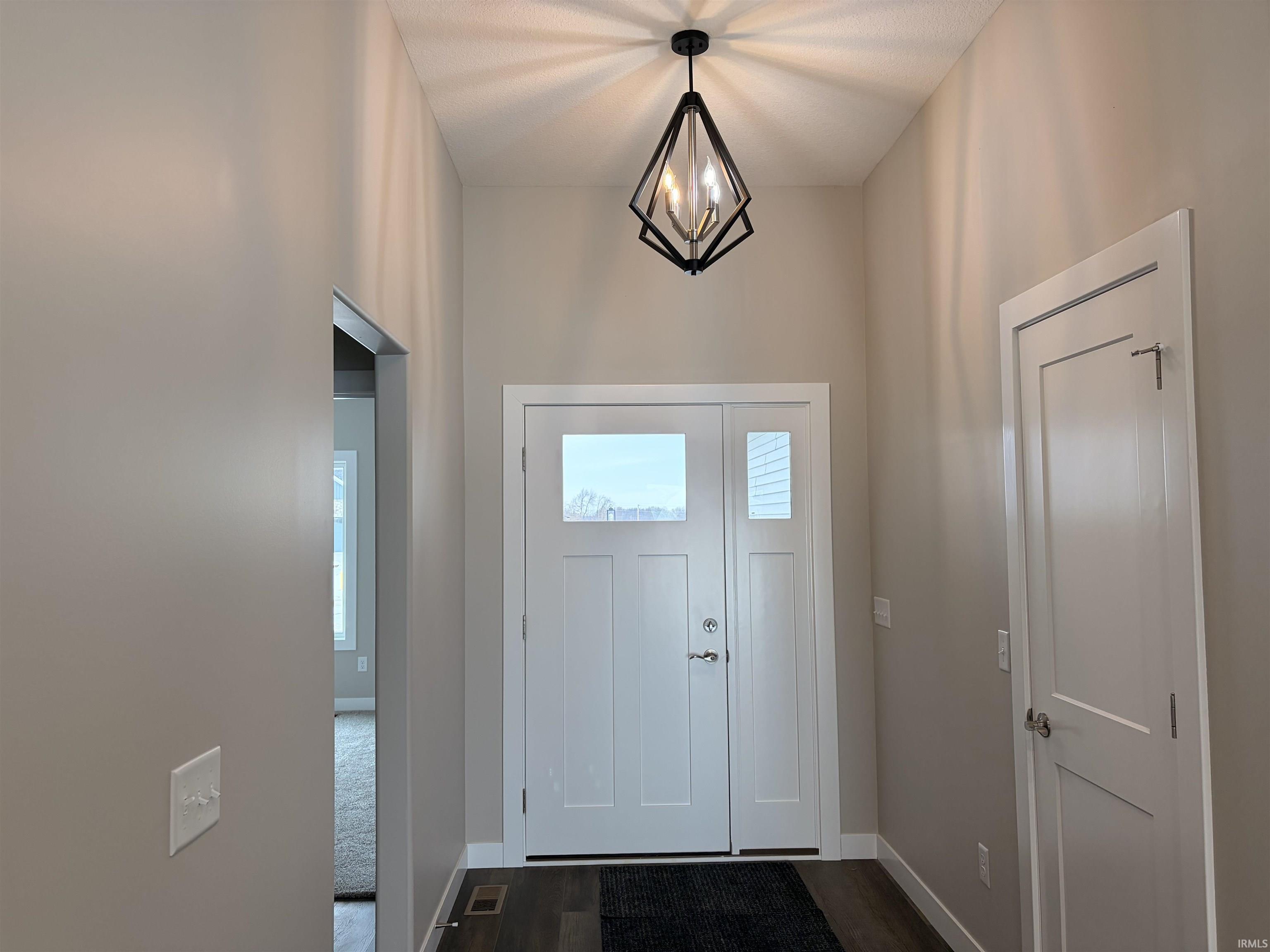 Entryway featuring dark wood-style flooring and baseboards