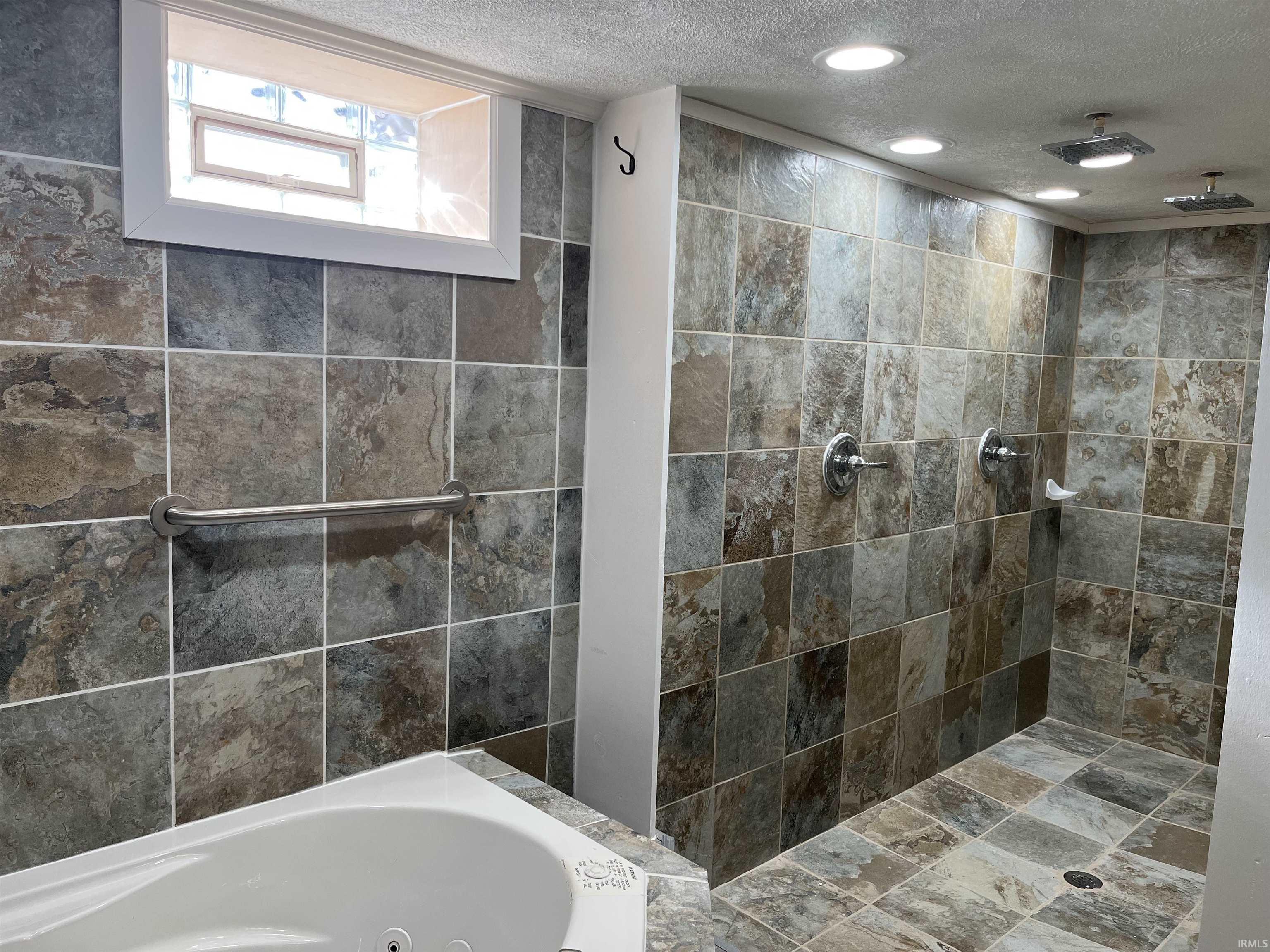 Lower Level Full bath with a textured ceiling, a tile shower, a tub with jets, and recessed lighting