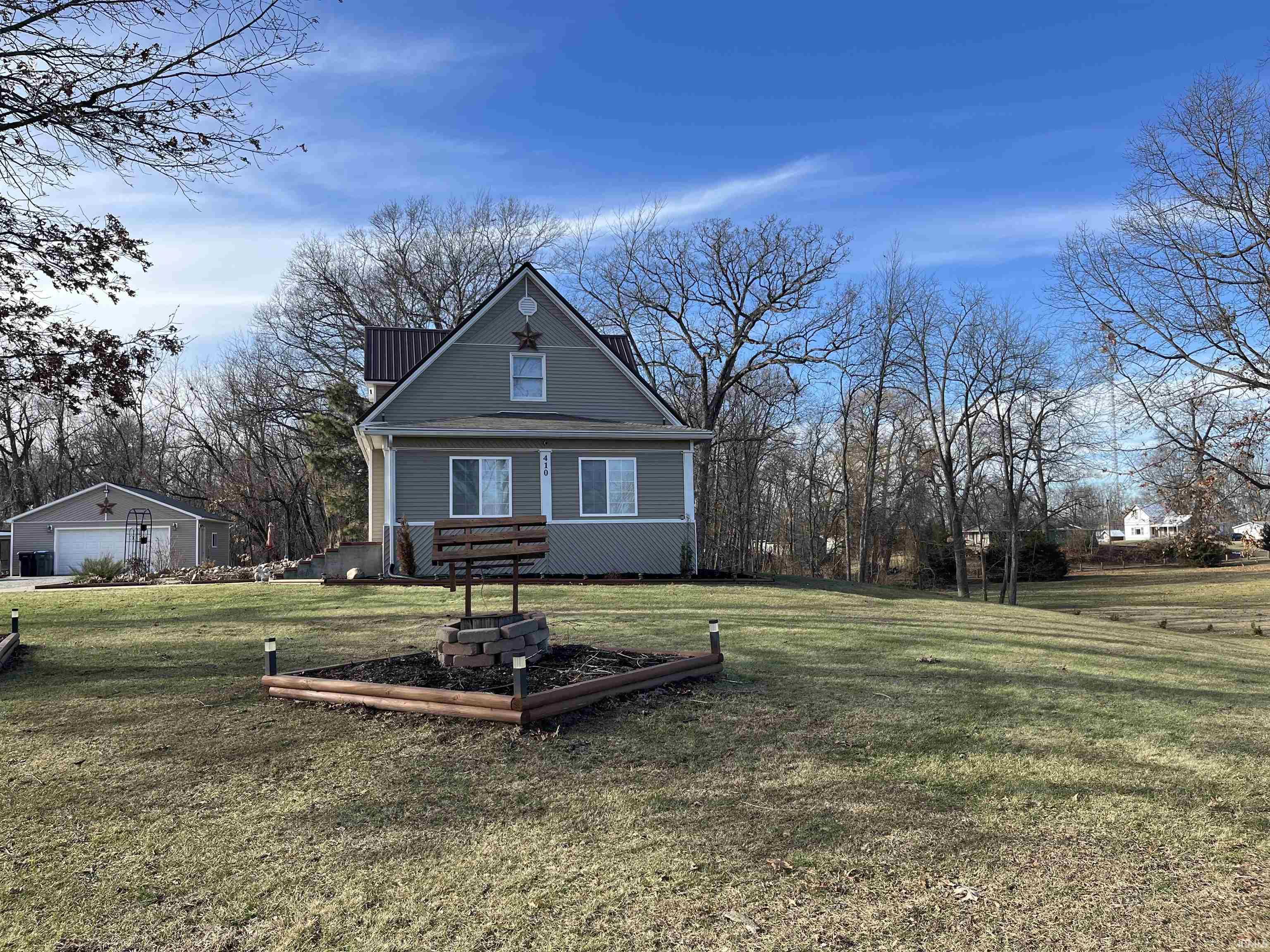 View of front of house featuring a front yard and a detached garage