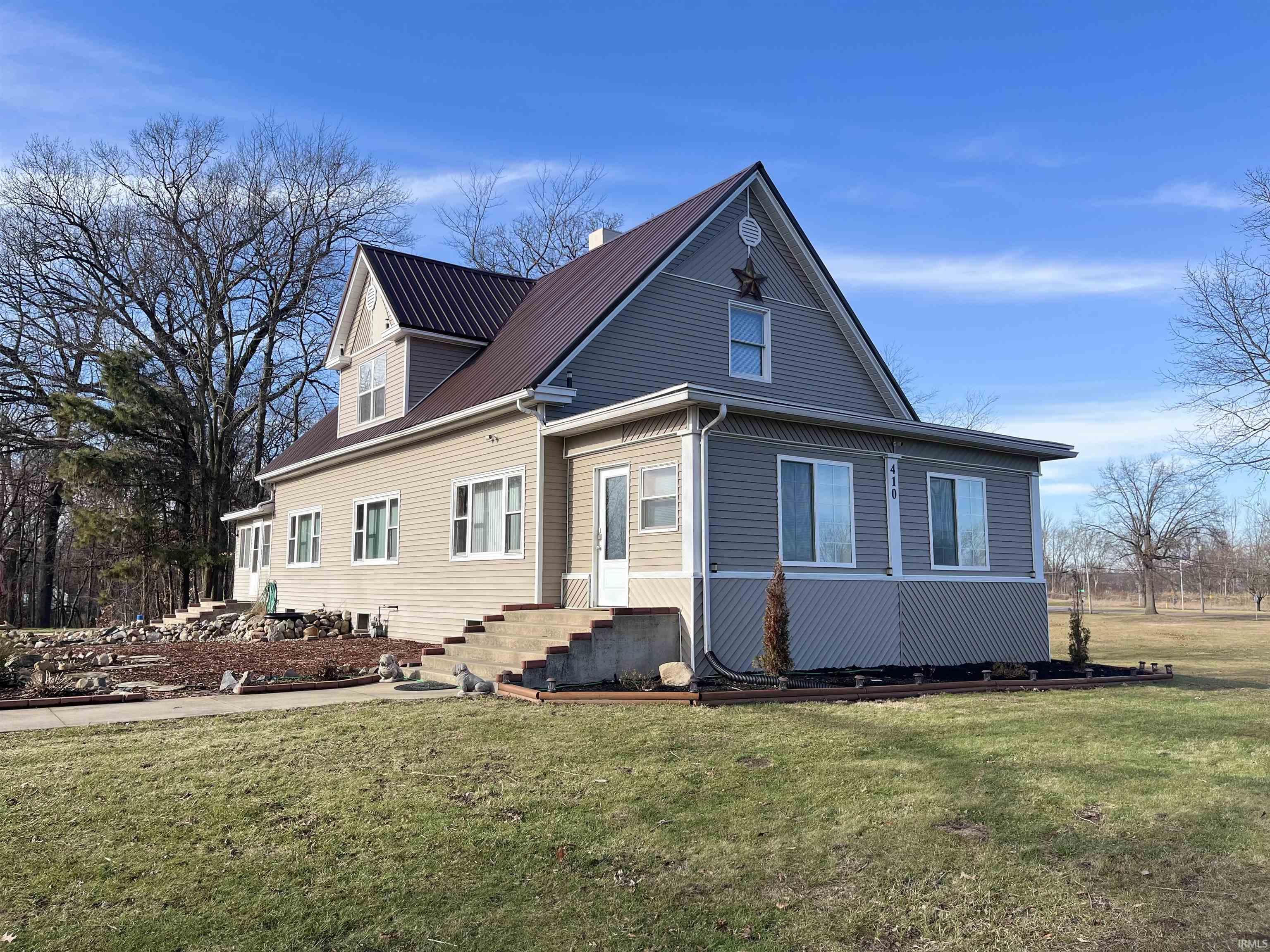 View of front of house featuring a front lawn and entry steps