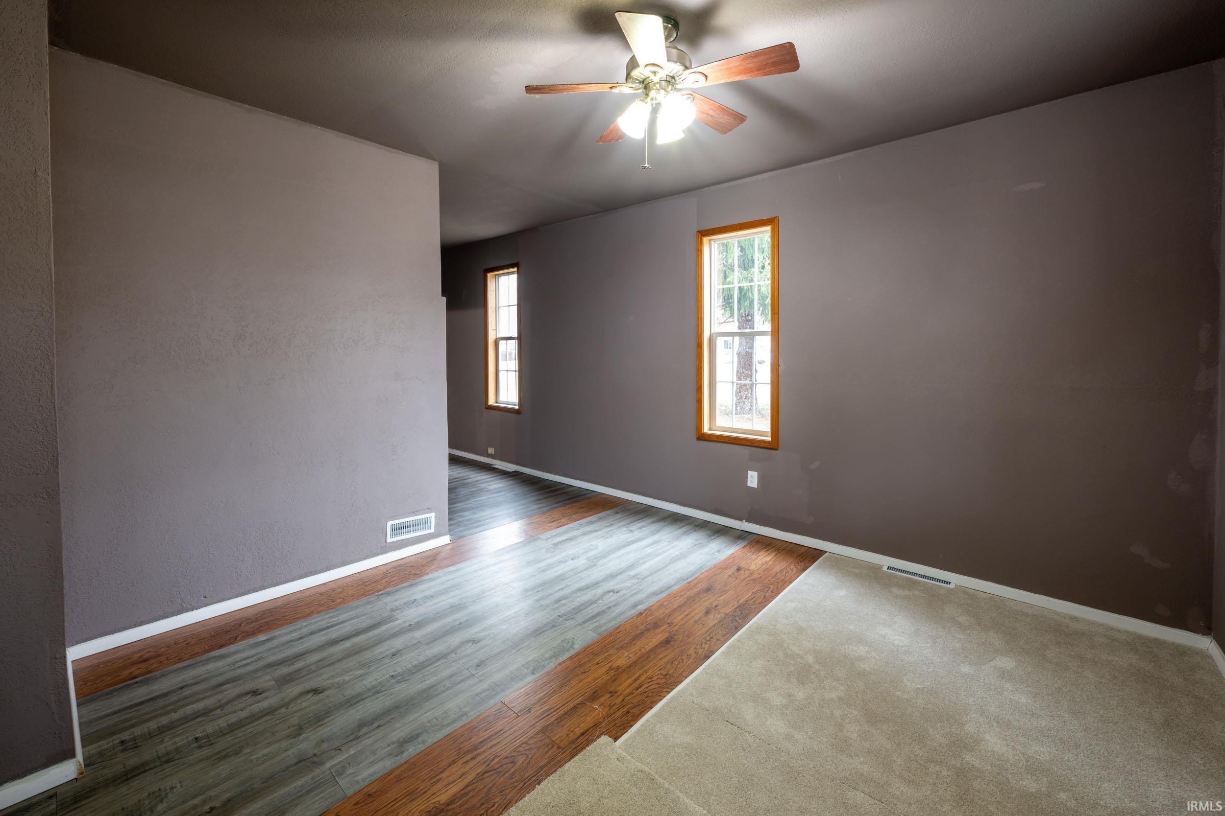 Empty room with wood finished floors and ceiling fan