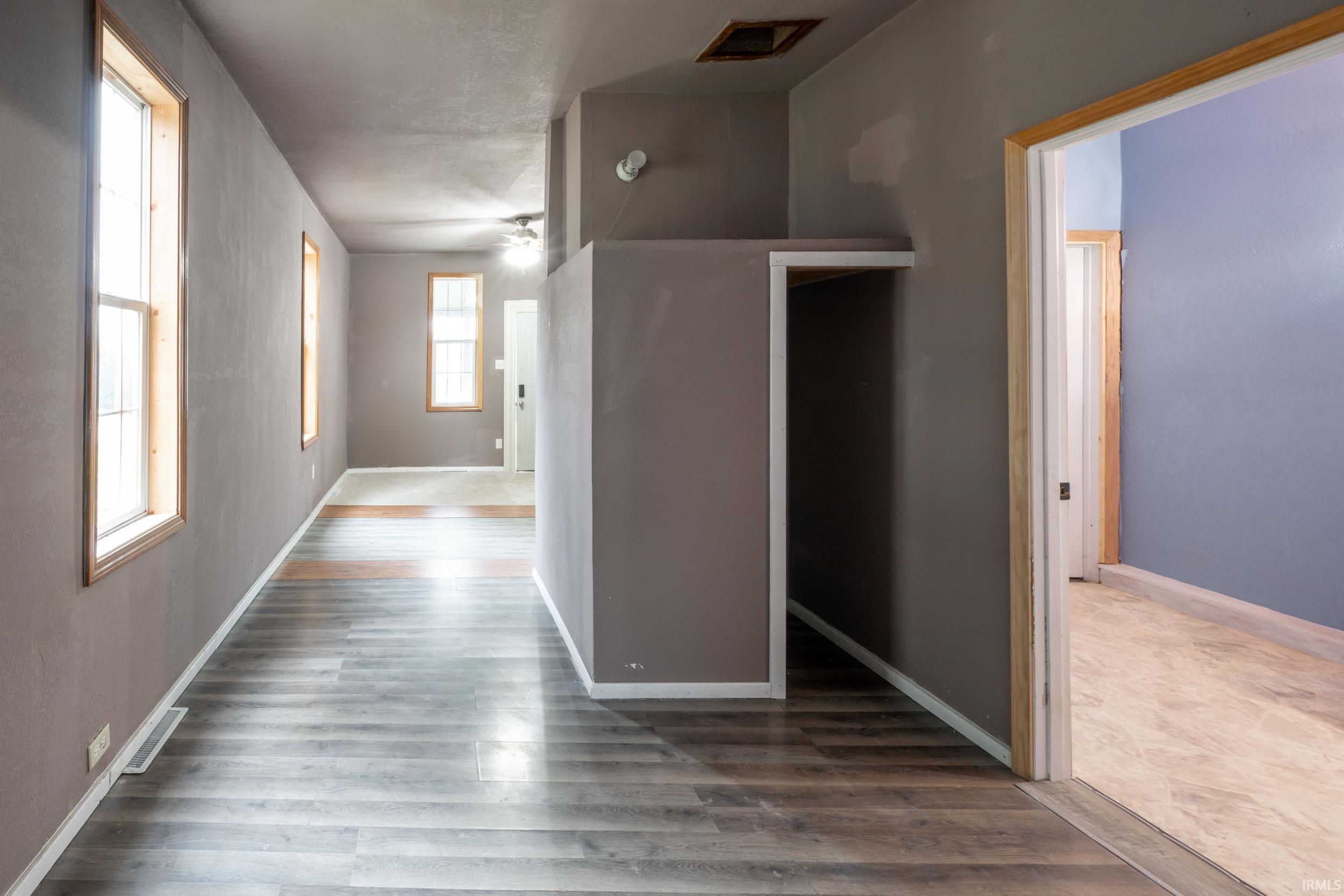 Hallway with baseboards and wood finished floors