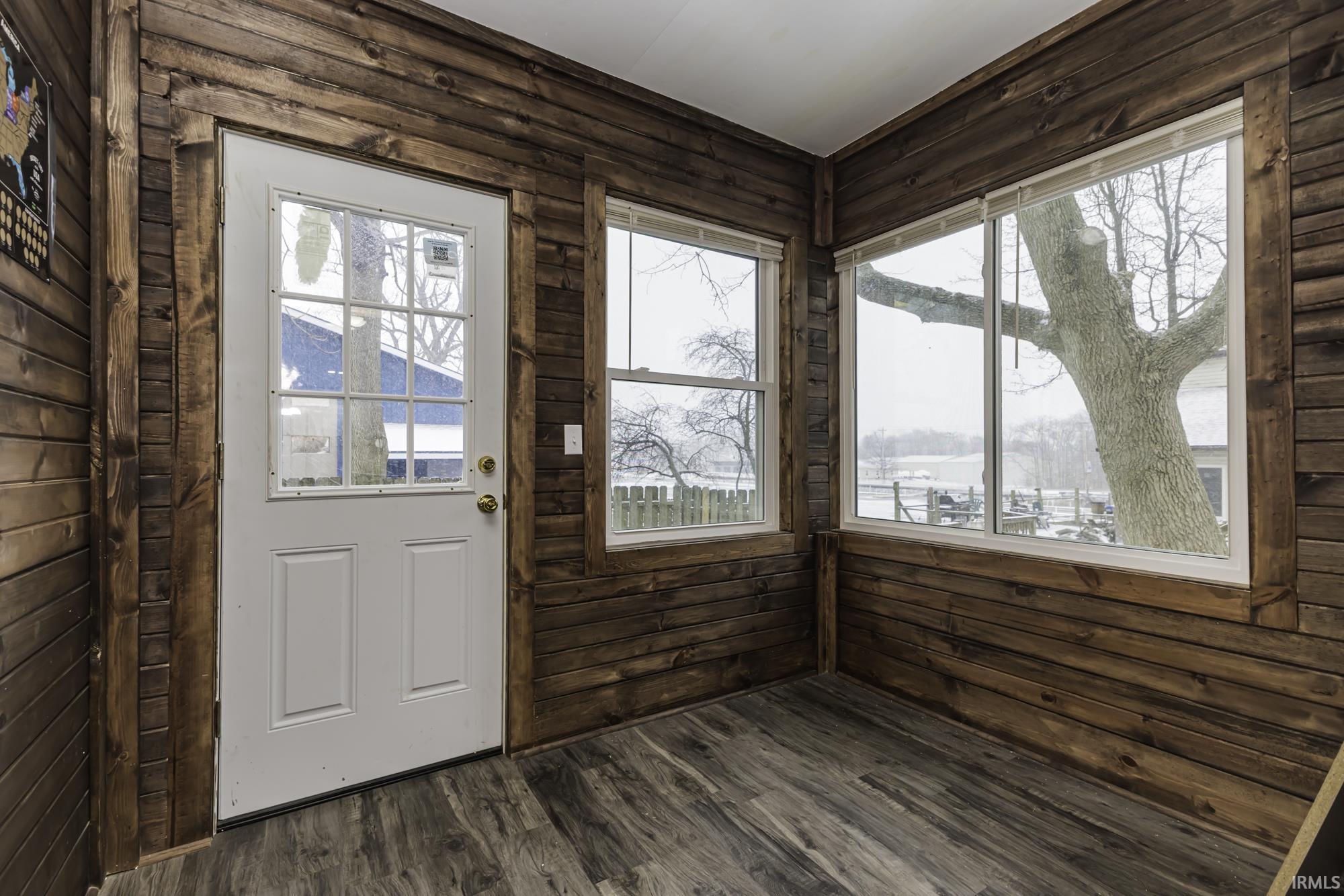 Doorway with wooden walls and wood finished floors