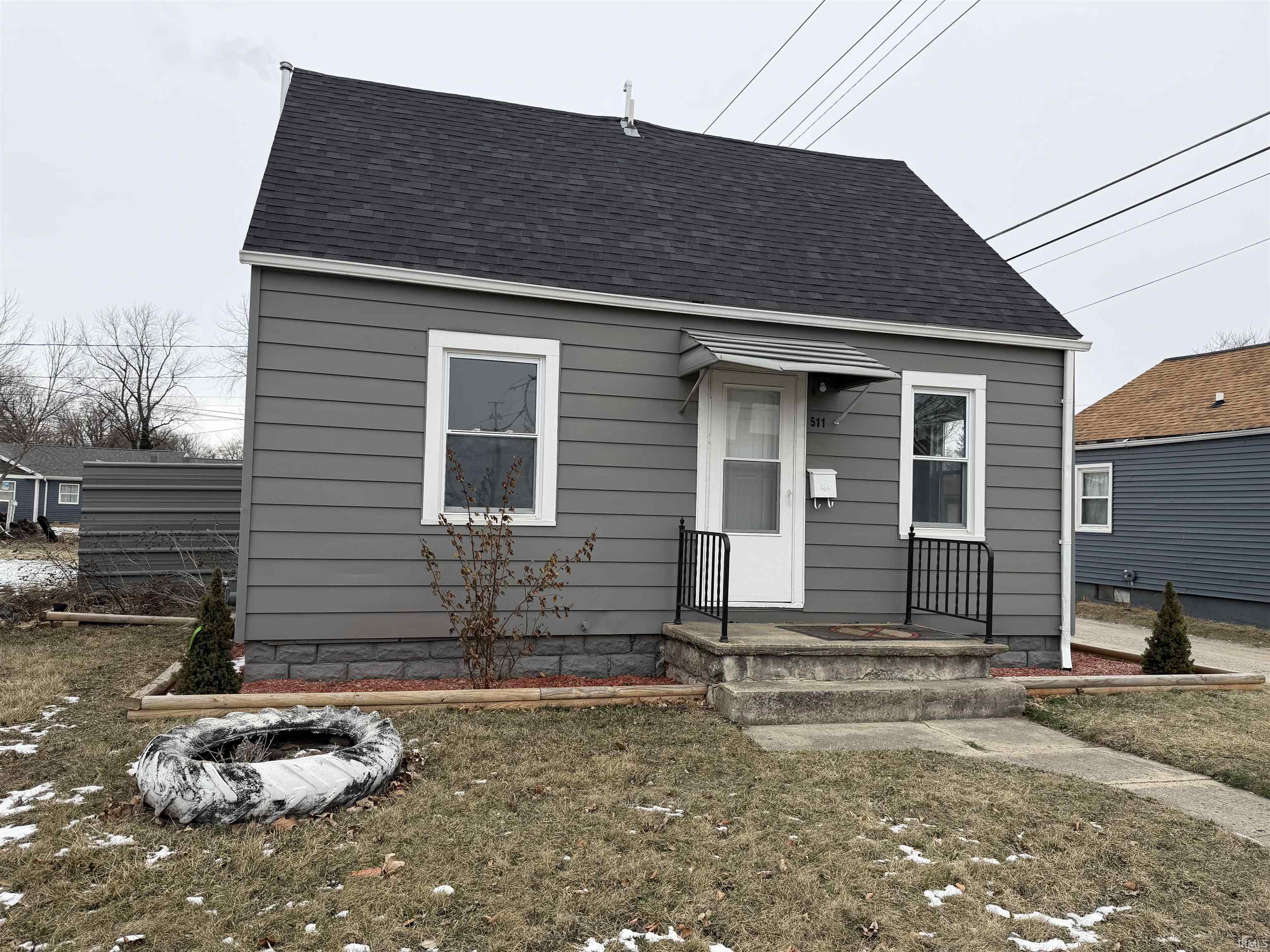View of front of home featuring roof with shingles and a front yard