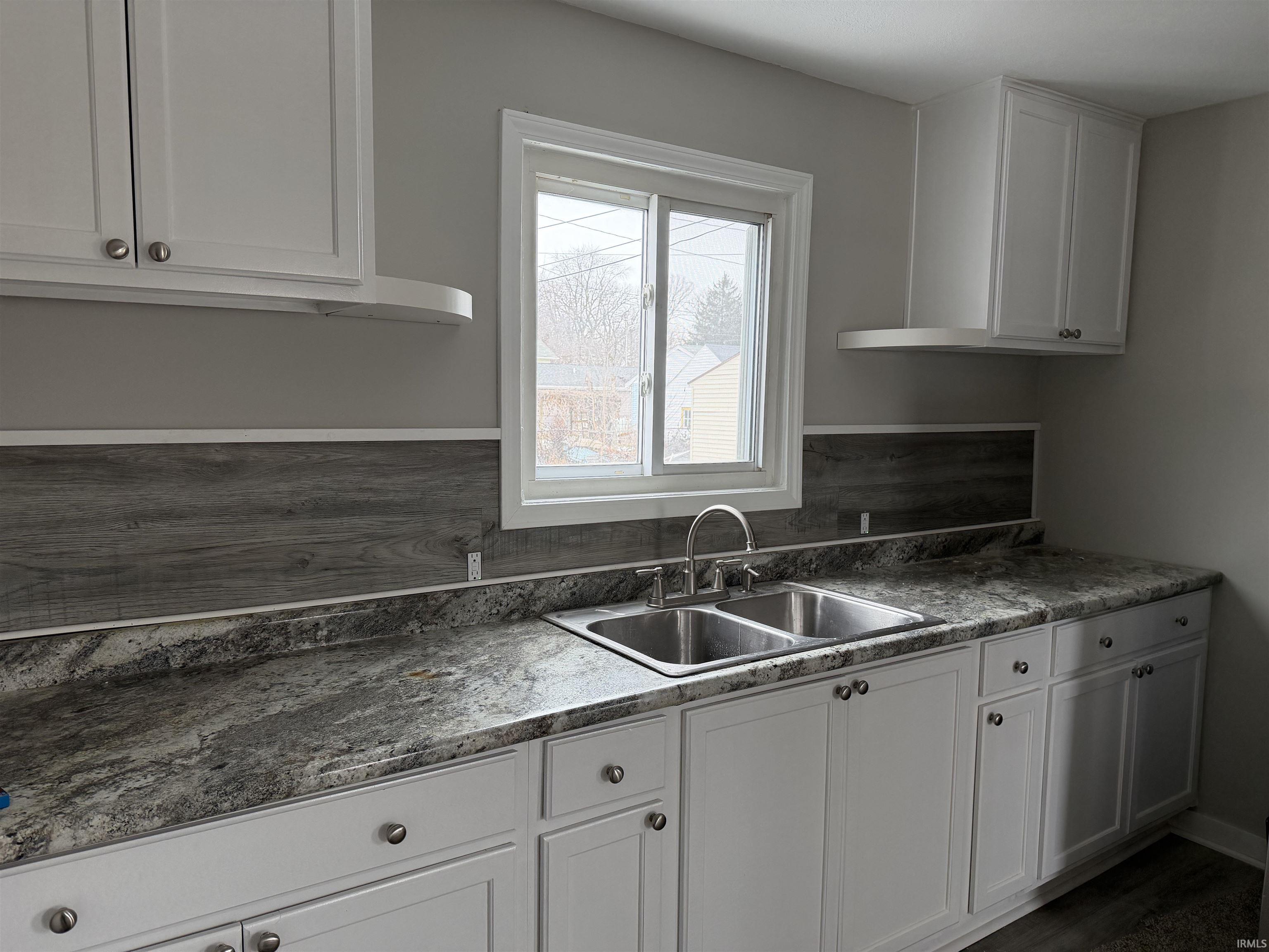 Kitchen with white cabinetry, dark countertops, and dark wood-style floors