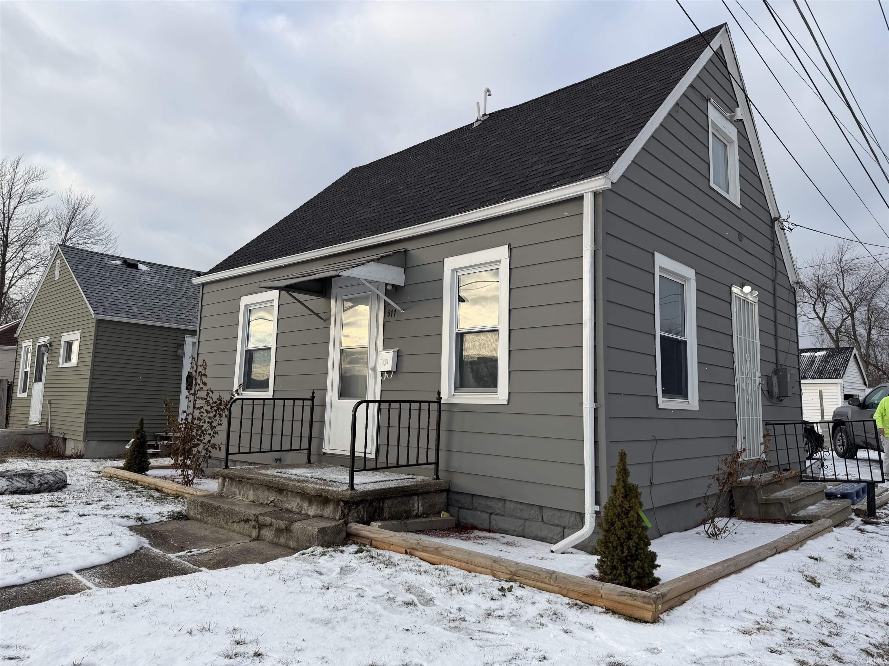 View of front of home with roof with shingles