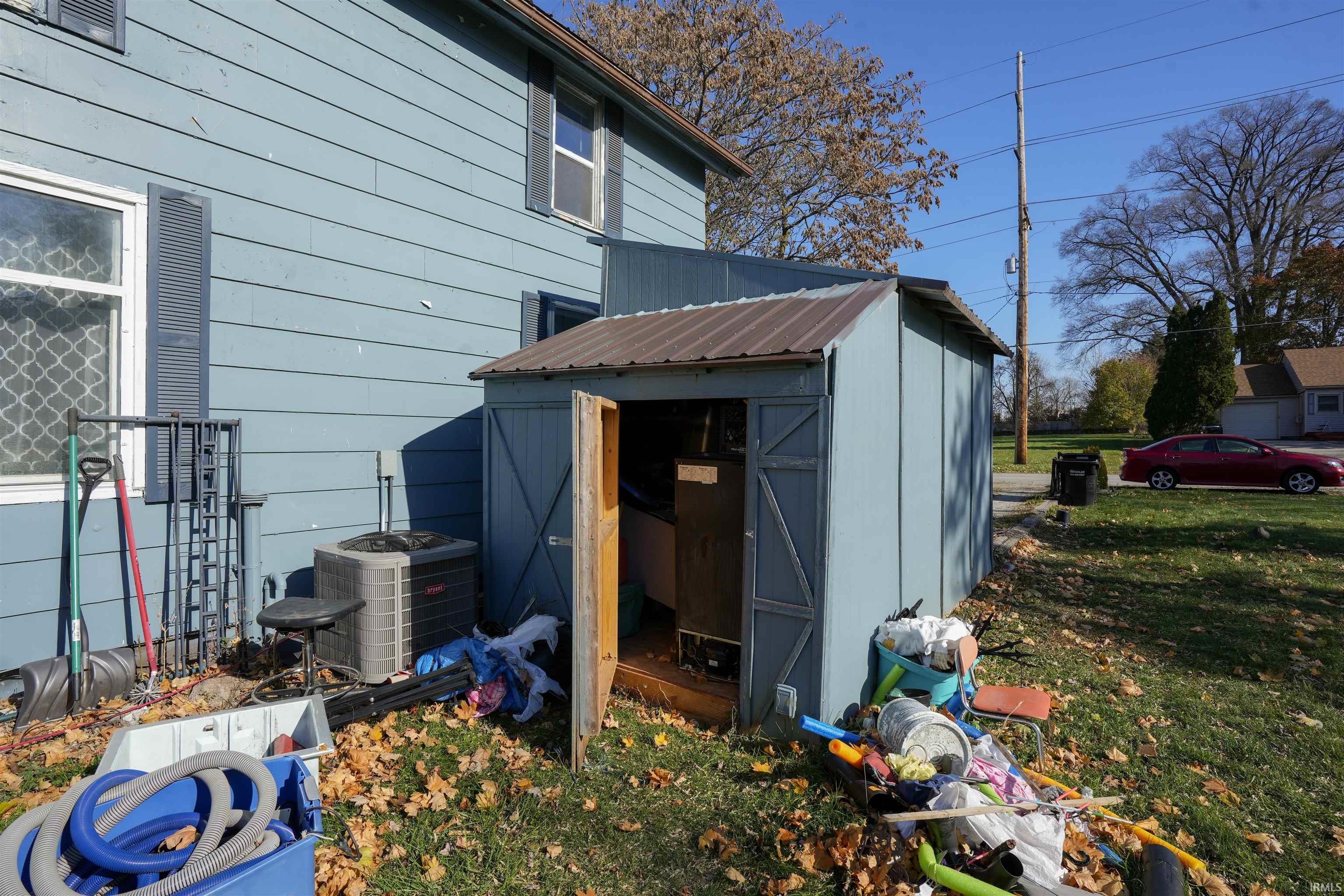 View of side of property featuring a storage unit and a yard